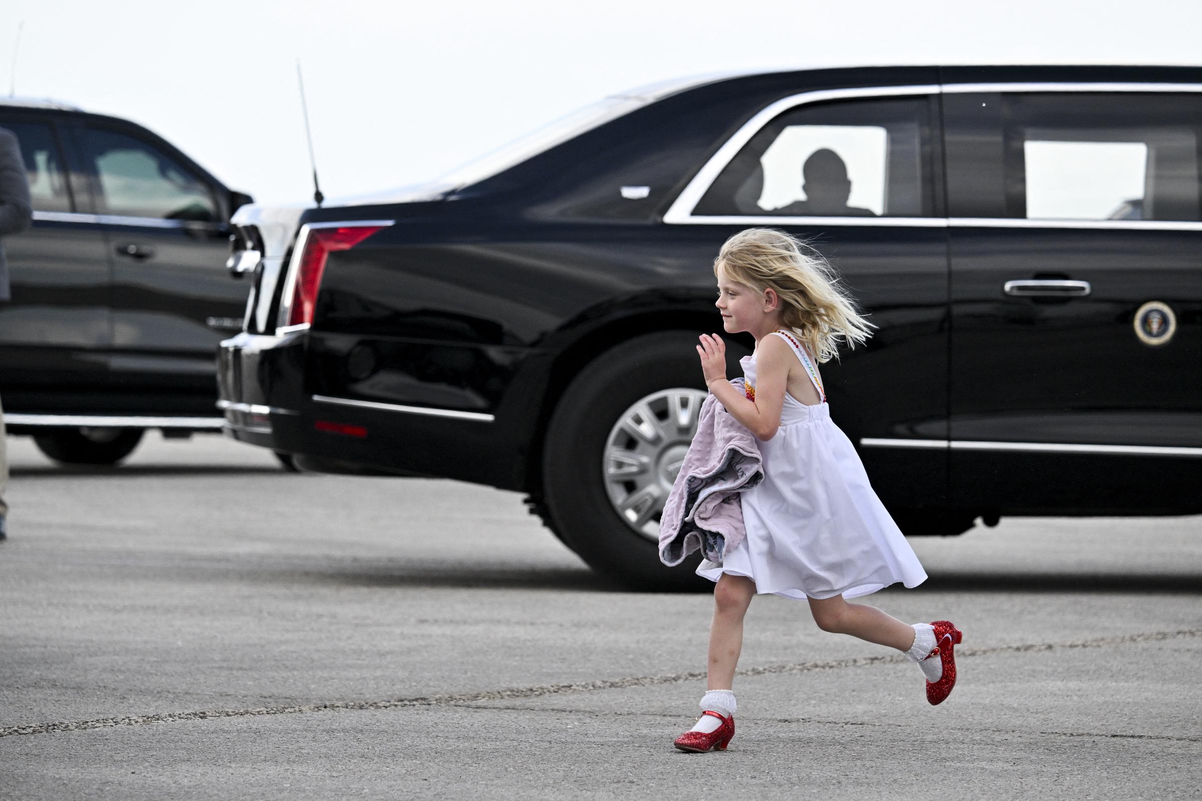 Carolina Trump, the daughter of Eric and Lara Trump, runs on the tarmac of the Palm Beach International Airport after arriving with her parents and grandfather, US President Donald Trump, in West Palm Beach, Florida on February 16, 2025 | Source: Getty Images