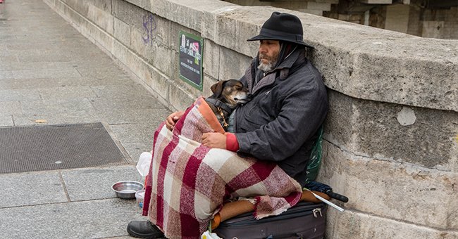 A homeless person and their dog. | Photo: Shutterstock