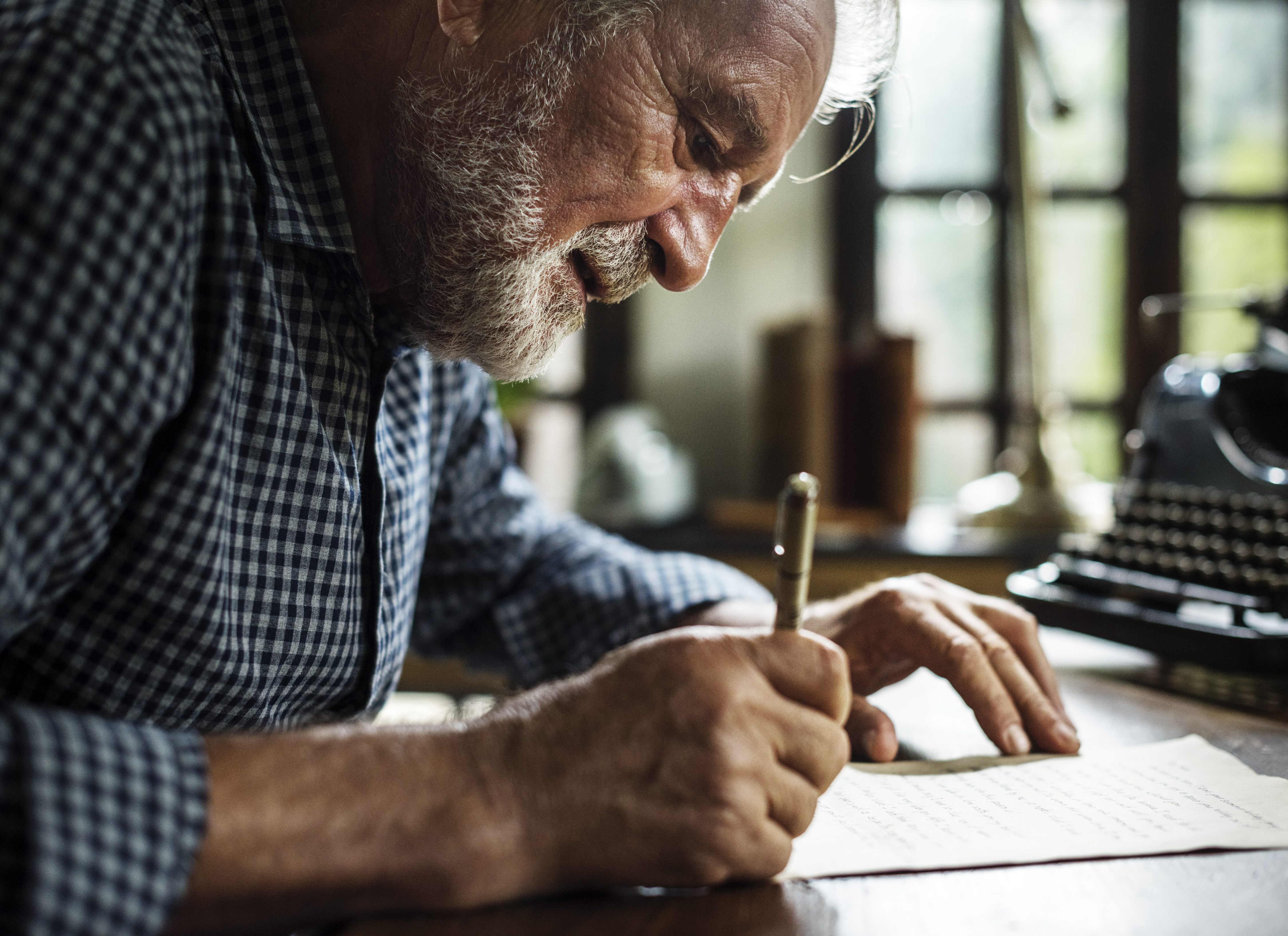 Closeup of senior man writing something. | Source: Shutterstock