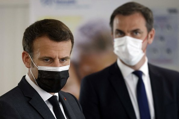 Emmanuel Macron et Olivier Veran lors de la visite d'un centre d'appel de la Sécurité sociale française.|Photo : Getty Images