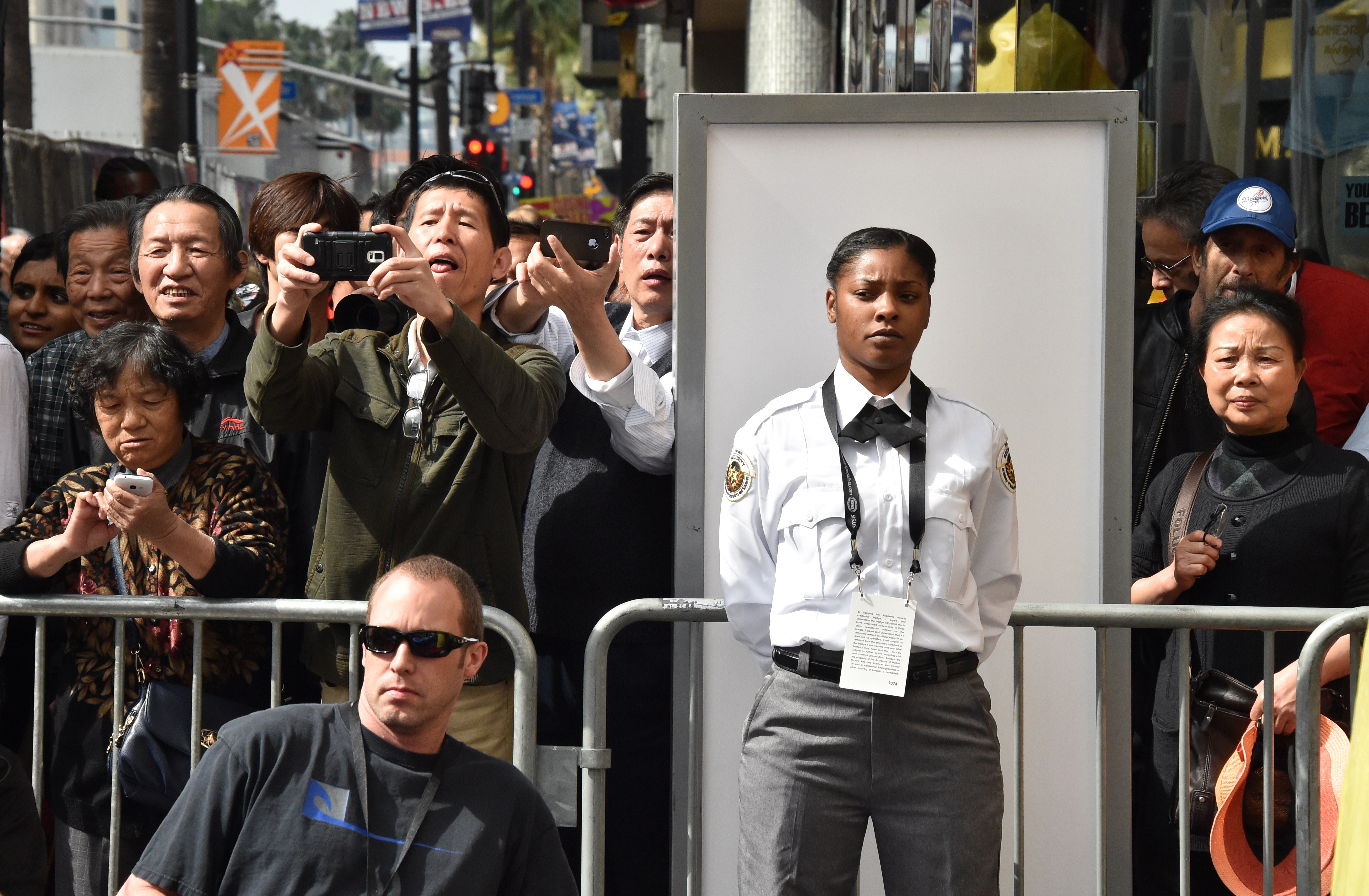 A security guard as tourists take photos of the red carpet outside the Dolby Theatre in Hollywood, California on February 21, 2015 | Source: Getty Images