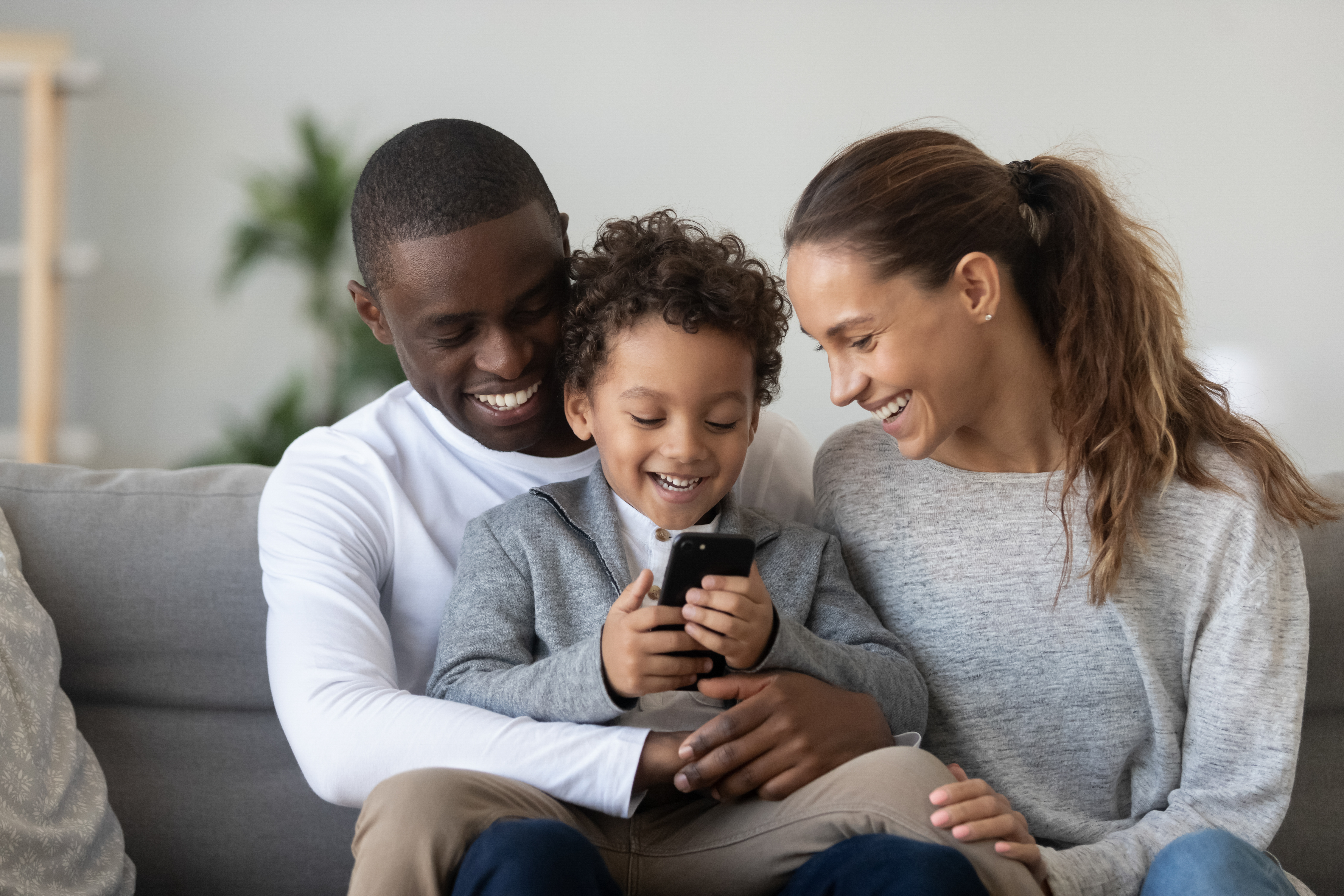 A mixed-race couple is pictured having fun with their little son at home | Source: Shutterstock