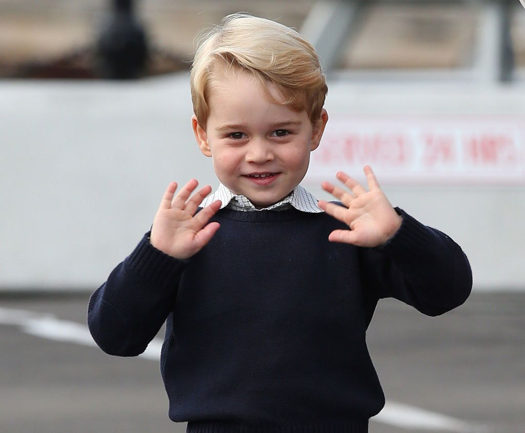 Prince George waves with both hands as he flashes a smile. | Source: Getty Images