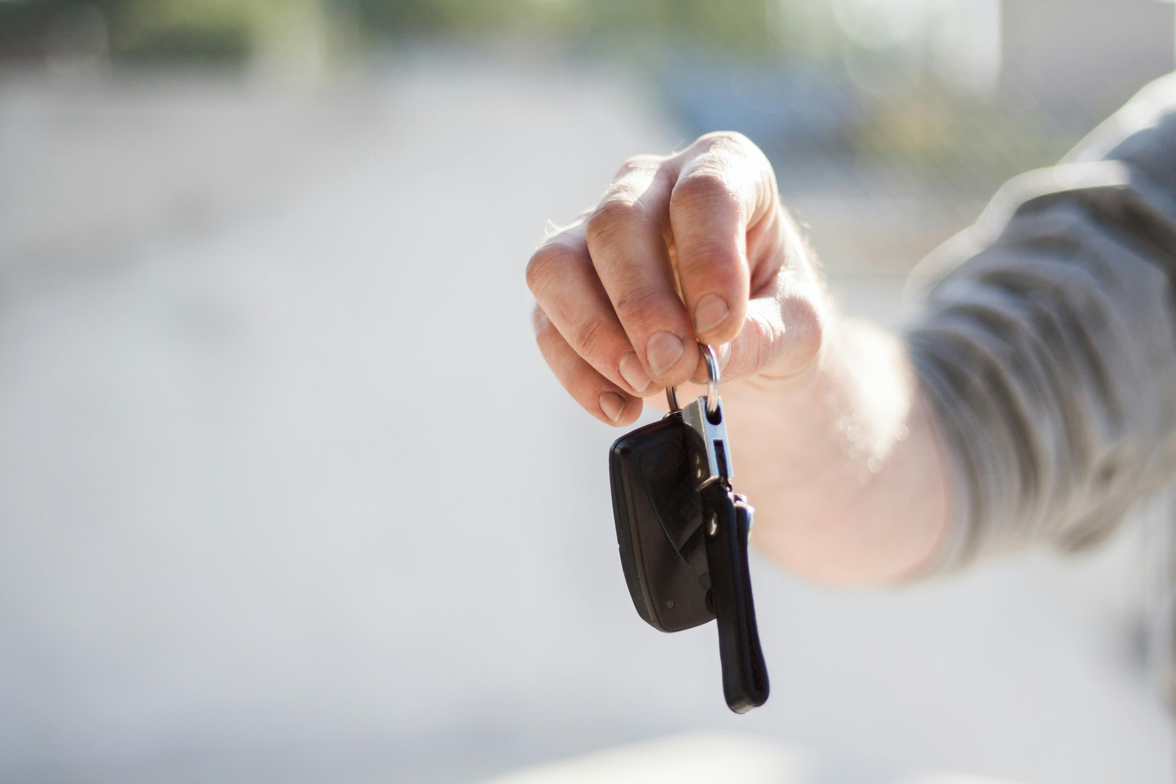 A hand holding up a car key | Source: Pexels