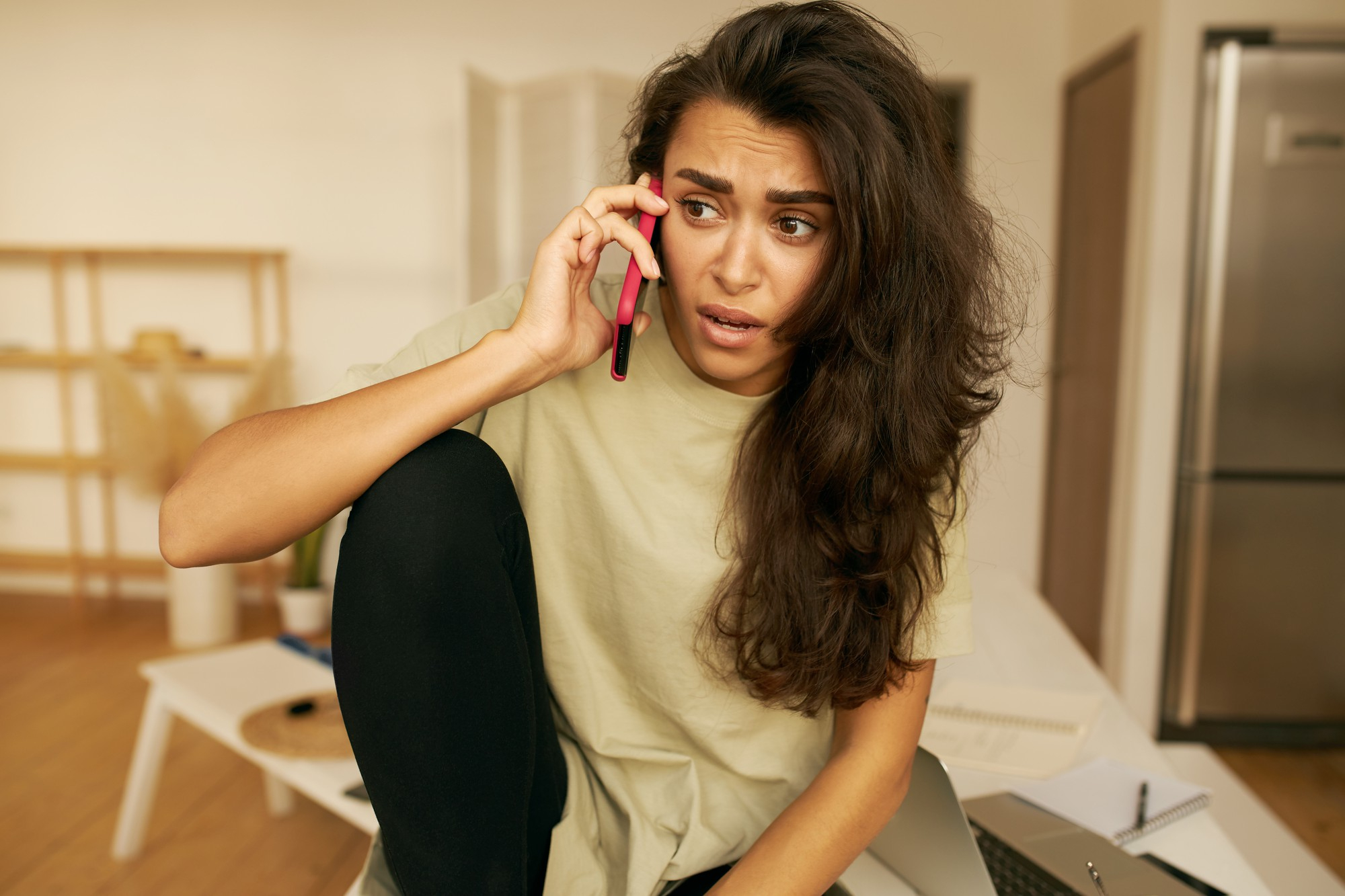 A woman looking surprised while talking on the phone | Source: Freepik