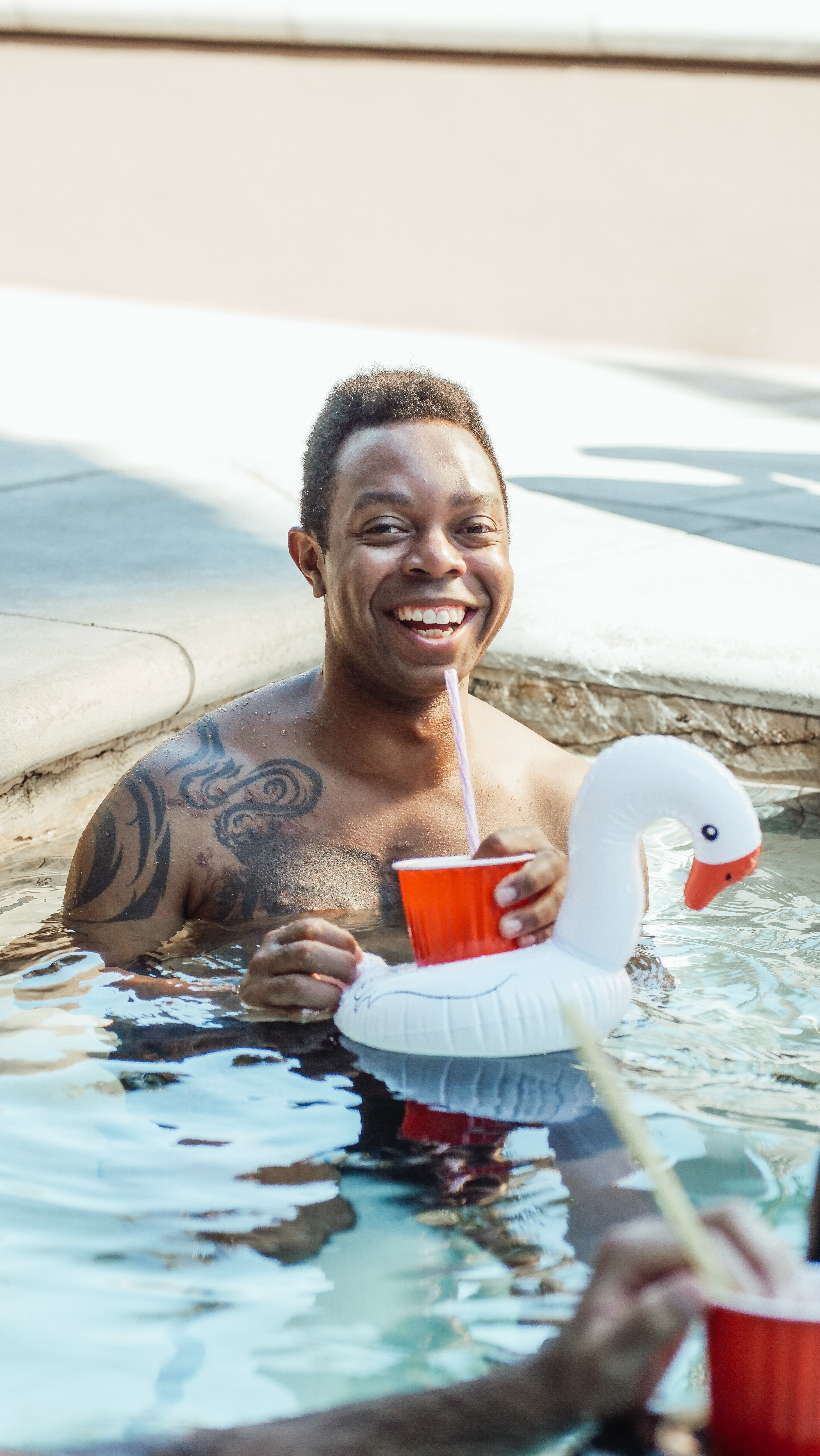 Man with tattoos in swimming pool. | Source: Pexels/ Kendel Media