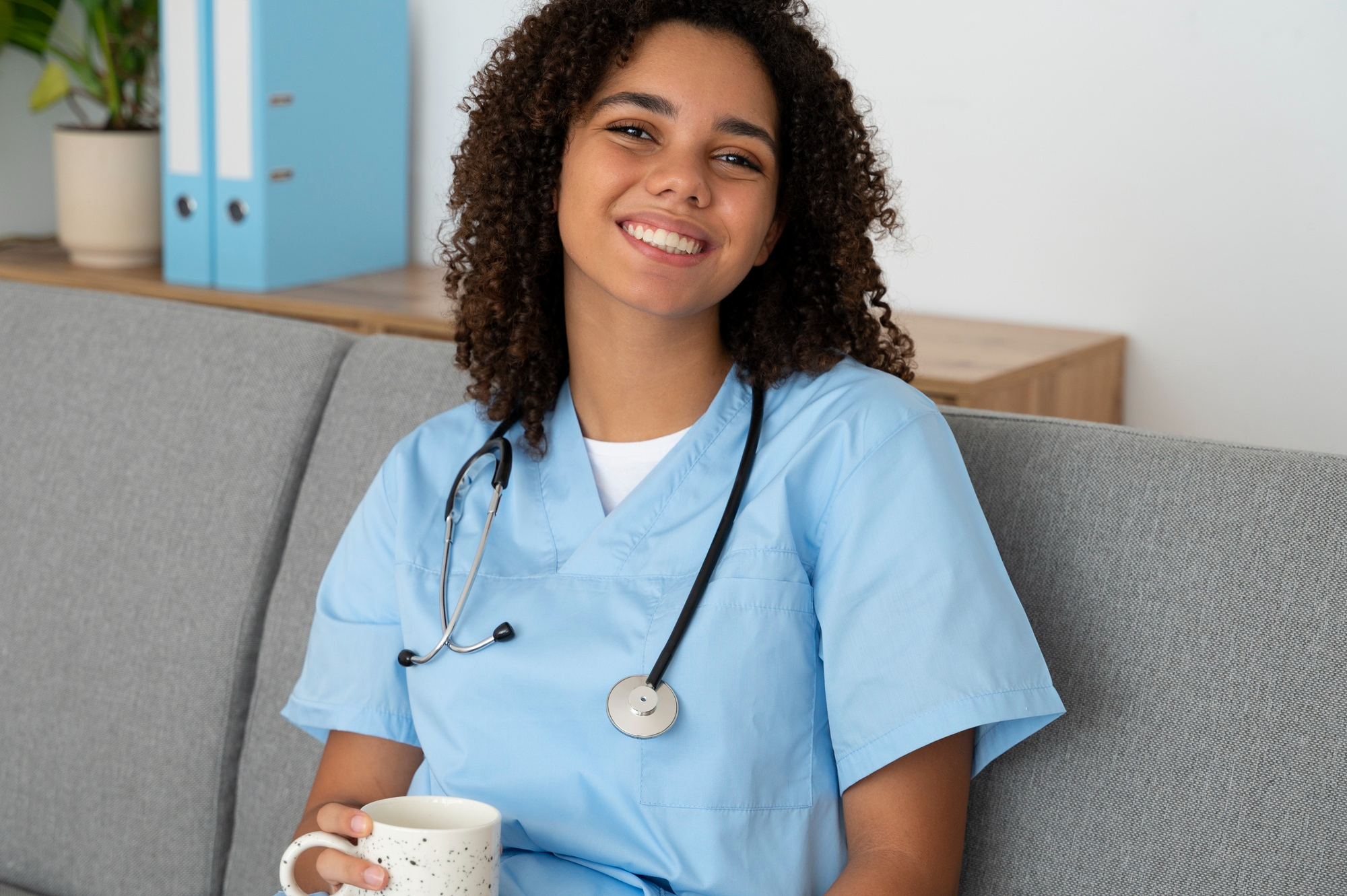 A happy nurse drinking a warm beverage | Source: Freepik