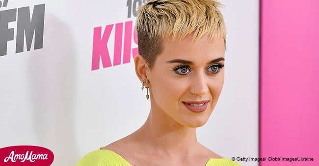 Katy Perry, 33, shows off a new tattoo on her wrist under a multi-colored light