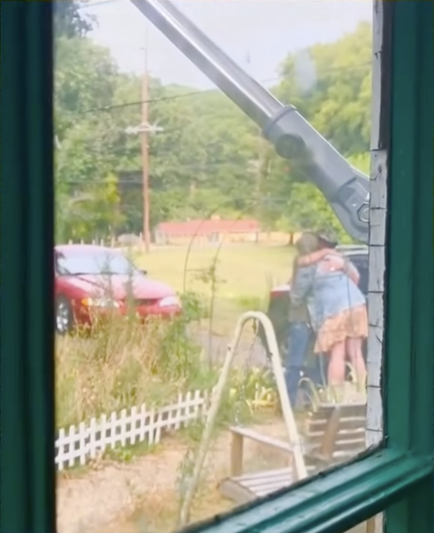 Hopie Feek hugs her biological father outside near a parked car, seen through a window in a video posted on February 8, 2025 | Source: Instagram/hopiefeek01