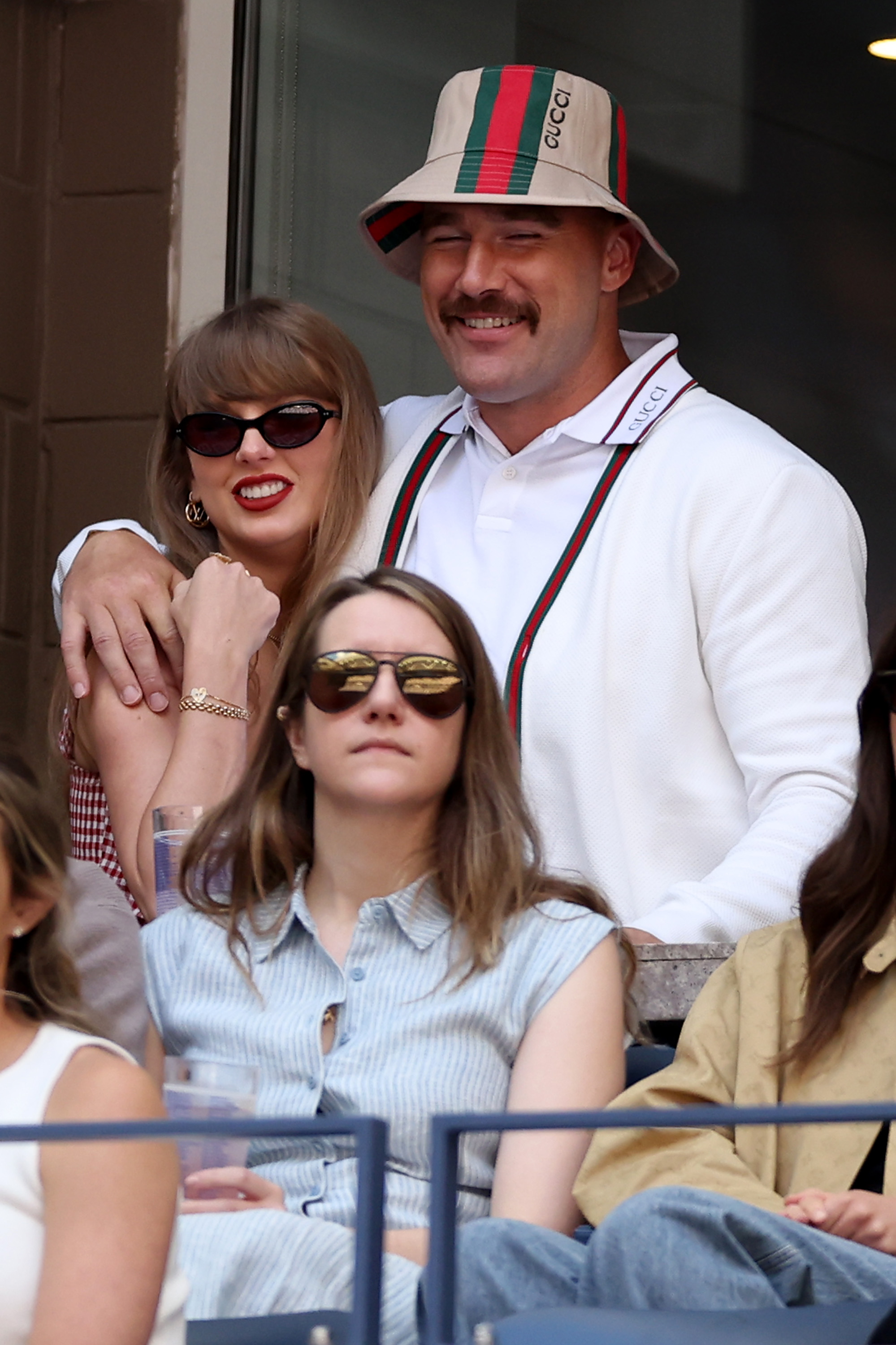Taylor Swift smiles as she leans into Travis Kelce, who has his arm around her and grins, as they watch the Men's Singles Final between Taylor Fritz of the United States and Jannik Sinner of Italy on Day Fourteen of the 2024 US Open at USTA Billie Jean King National Tennis Center on September 8, in the Flushing neighborhood of Queens, New York City.