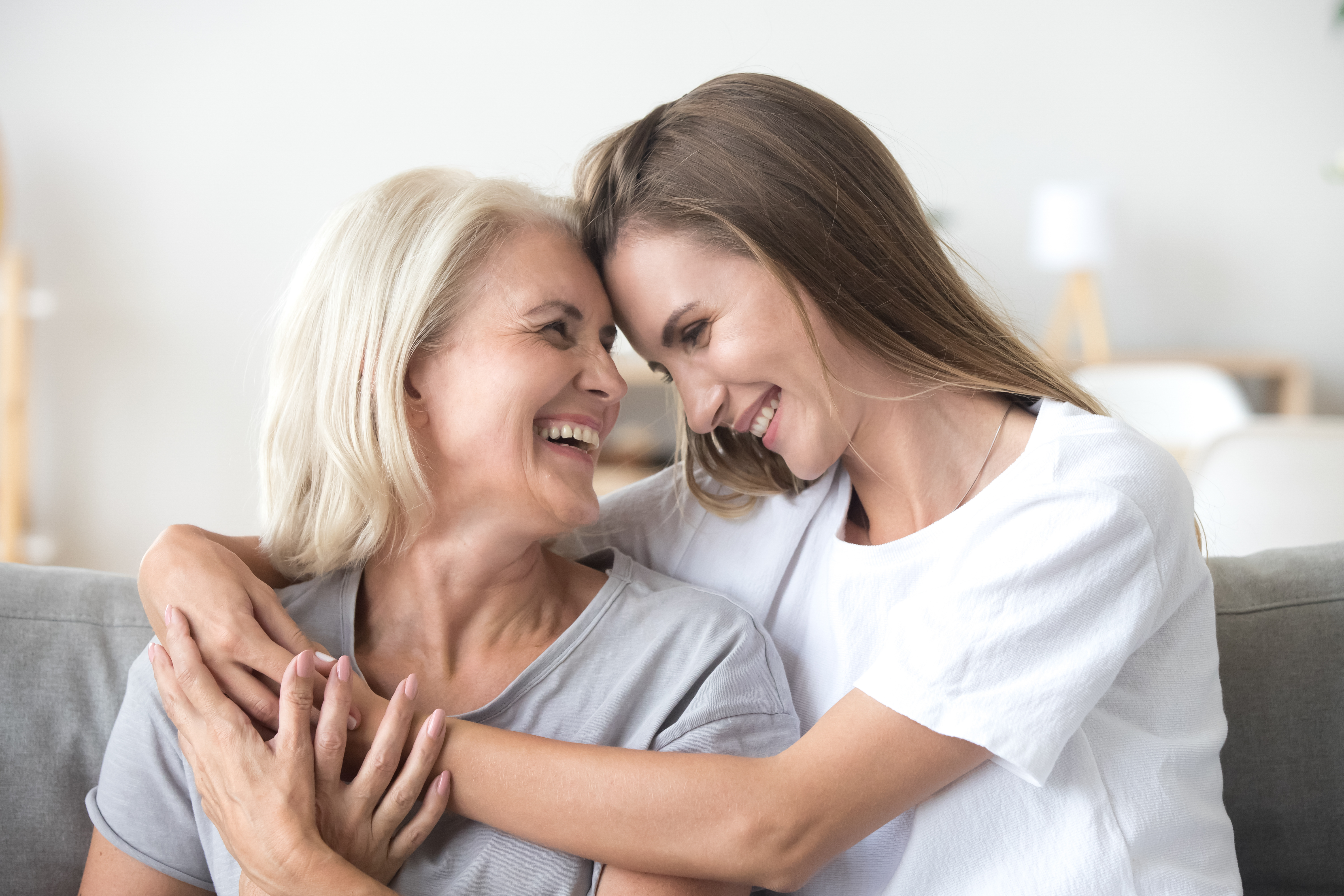 An older woman and a younger woman hud each other and laugh | Source: Shutterstock