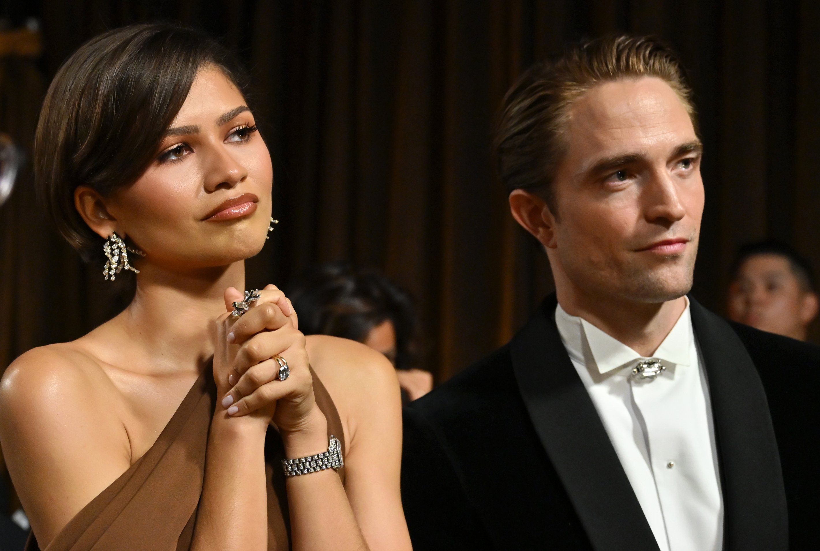 Zendaya and Robert Pattinson look on backstage during the 2026 Oscars. | Source: Getty Images