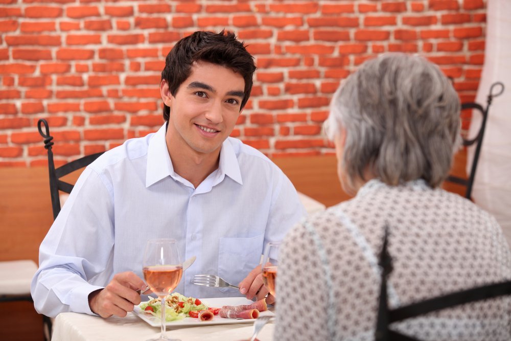 Une jeune homme déjeunant avec sa mère. | Shutterstock