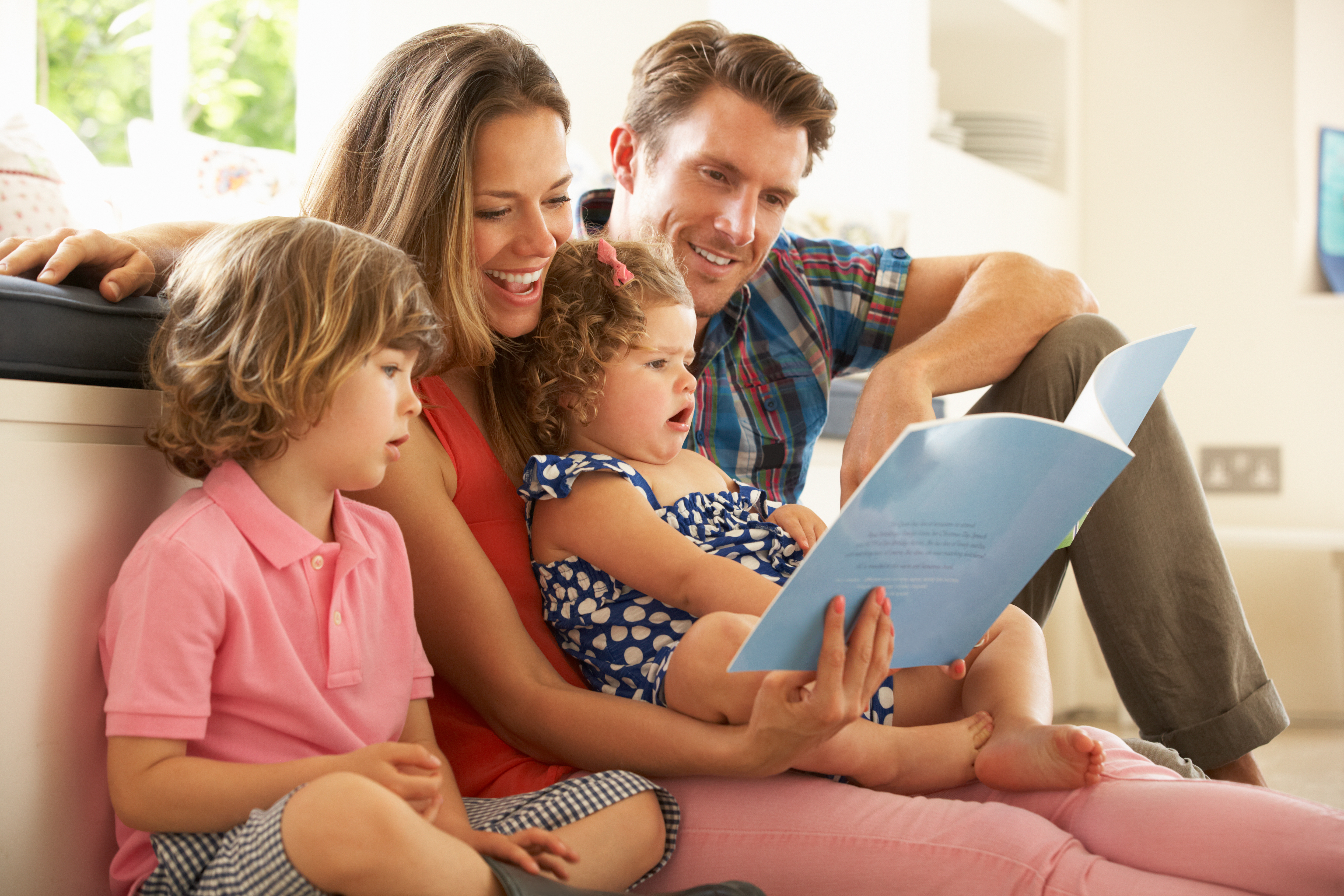 A family reading a book together | Source: Shutterstock