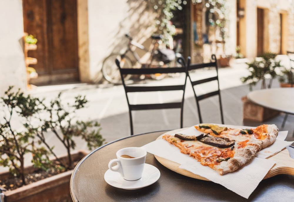 Cup of espresso coffee with slices of pizza. | Source: Shutterstock