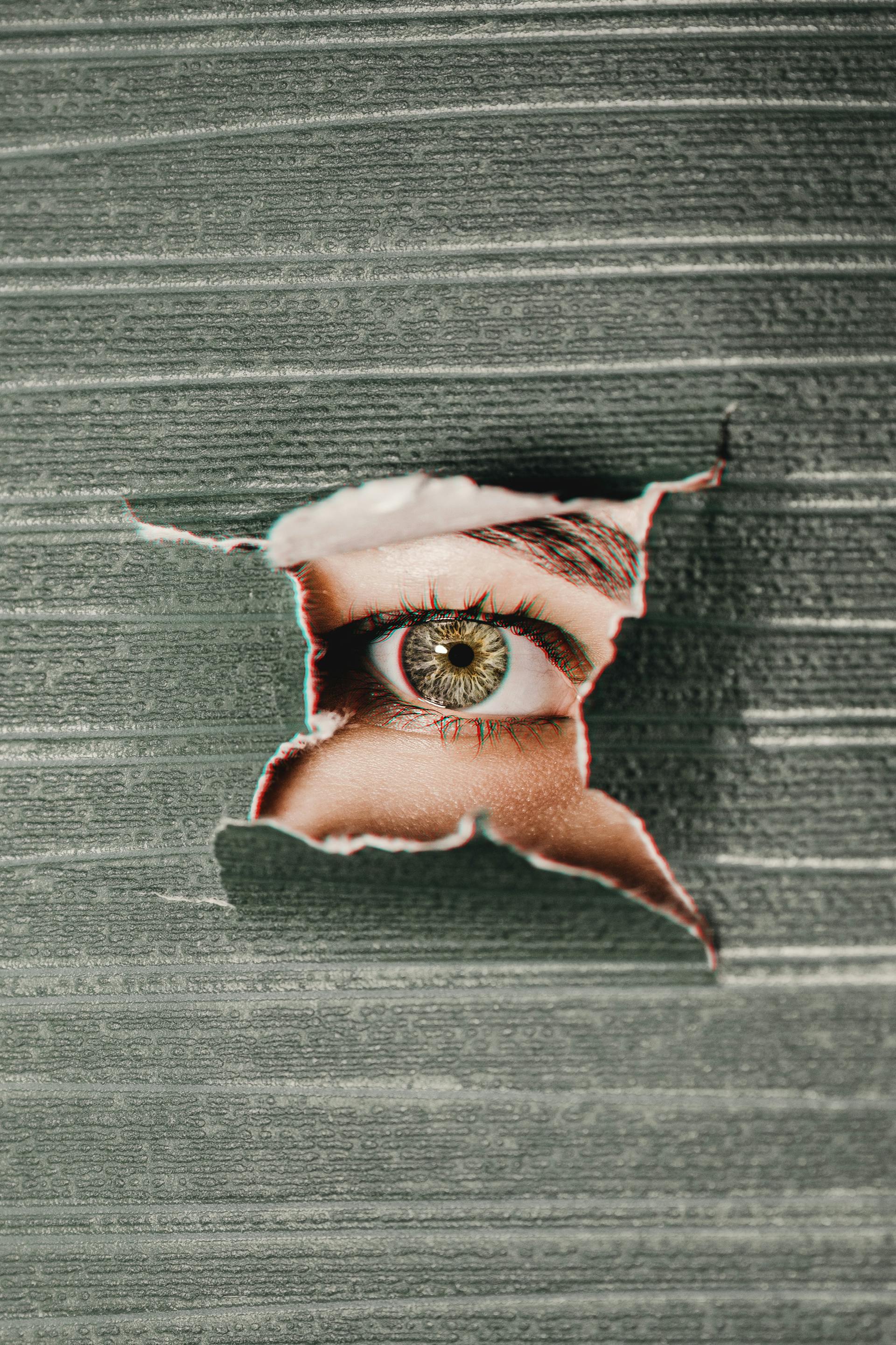 An eye peering through a wall | Source: Pexels