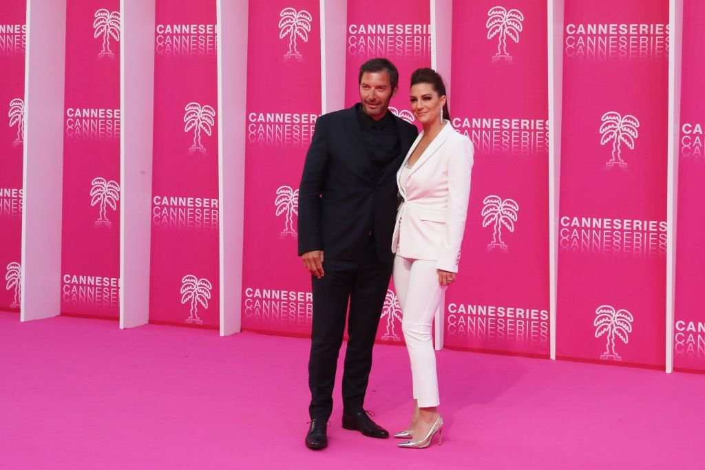 L'acteur français Franck Semonin (L) et son épouse Hélène posent à l'arrivée pour la cérémonie d'ouverture de la 2e édition du Festival International des Séries de Cannes (Canneseries) le 5 avril 2019. | Photo : Getty Images