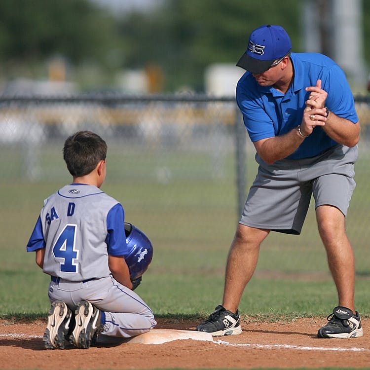 Vater und Sohn während eines Baseballtrainings im Freien. | Quelle: Pexels