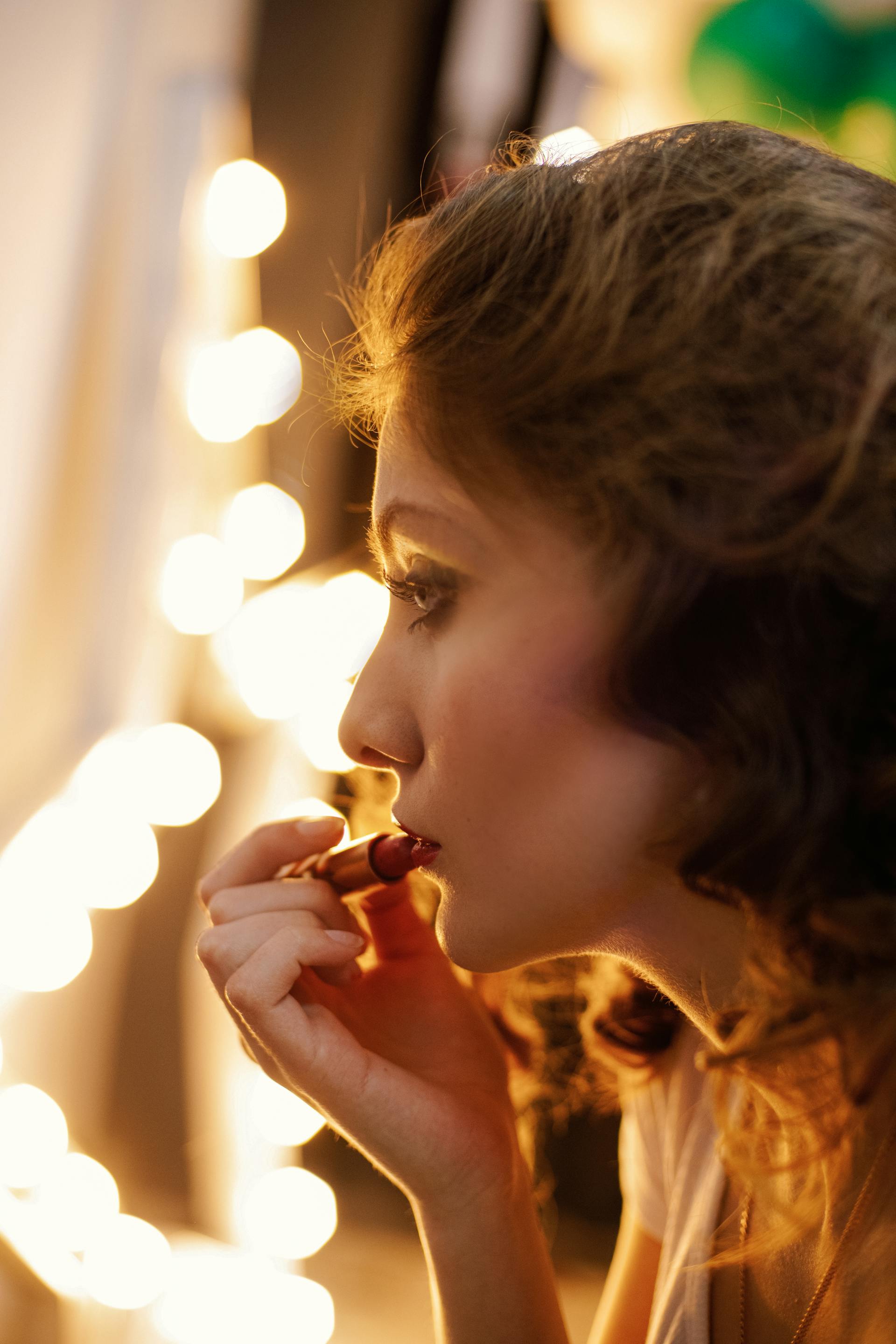 A woman putting on lipstick | Source: Pexels