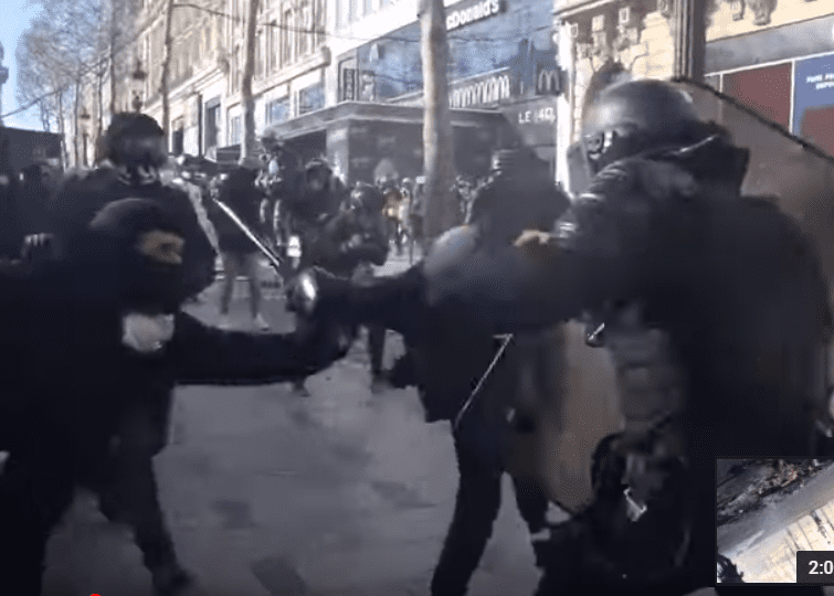 Les manifestants s'attaquent à un policier sur les Champs-Elysées, le 16 mars 2019. | Photo : Youtube/InfoCritiqueWeb