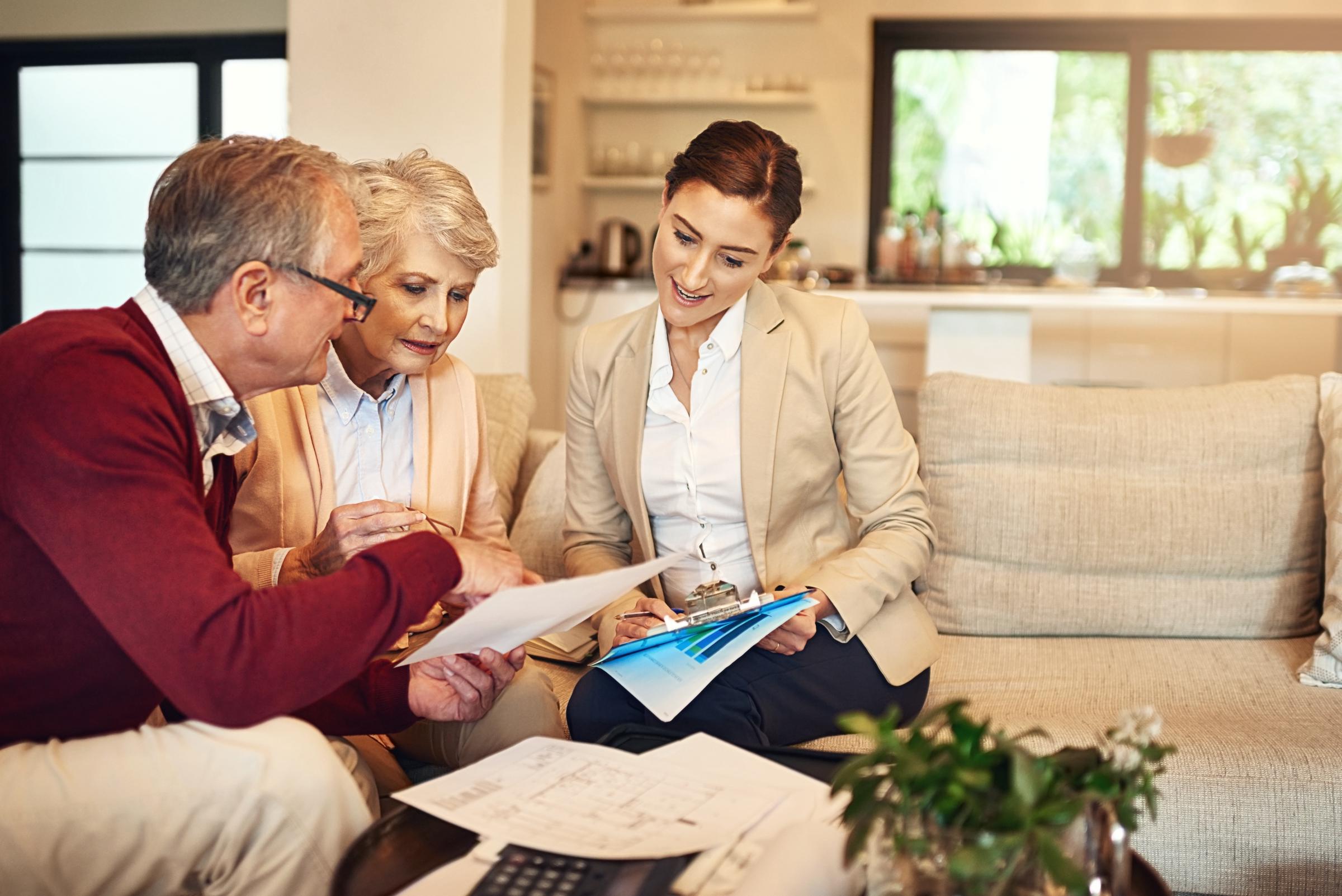 A senior couple consulting with a younger woman | Source: Shutterstock
