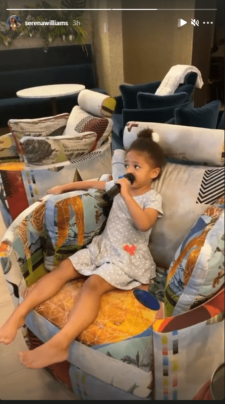 Serena Williams' daughter Alexis Olympia holding a microphone while sitting on a couch. | Photo: www.instagram.com/serenawilliams