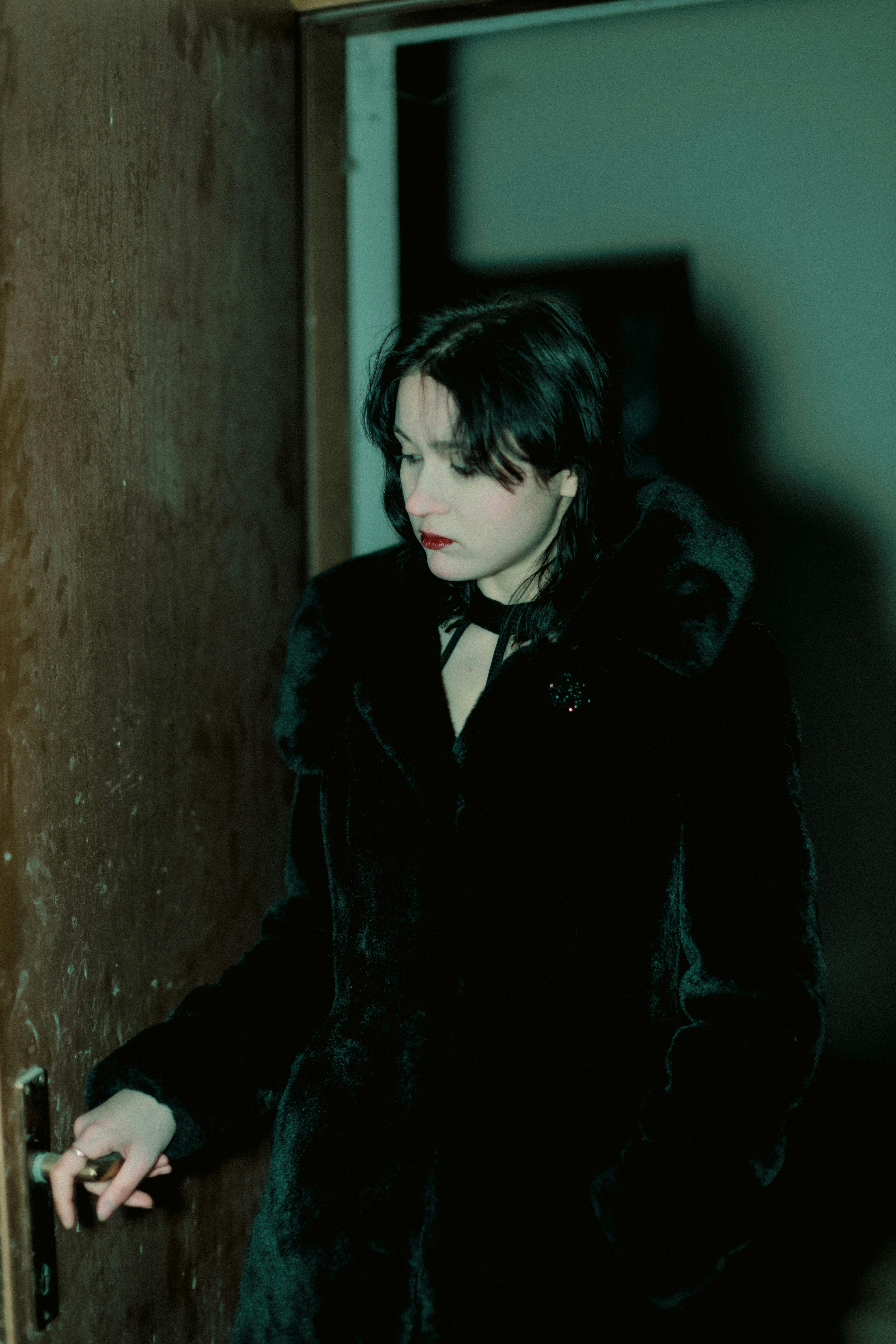 Woman holding a door knob | Source: Pexels