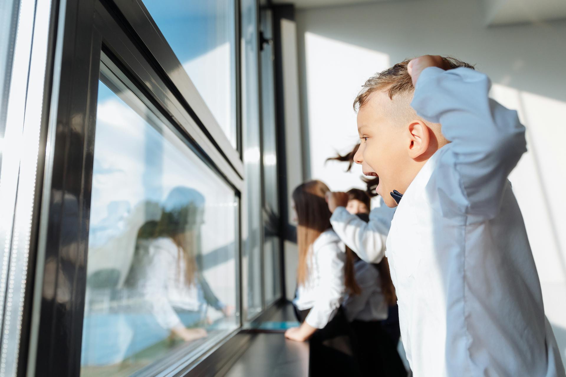 A boy looking outside a window | Source: Pexels