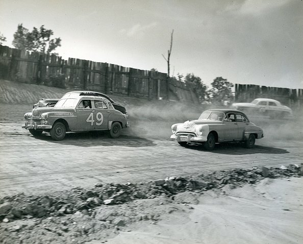 Glenn Dunaway in a 1949 Plymouth (No. 49) battles with Dick Burns during the NASCAR Cup race at Charlotte Speedway. | Photo: Getty Images