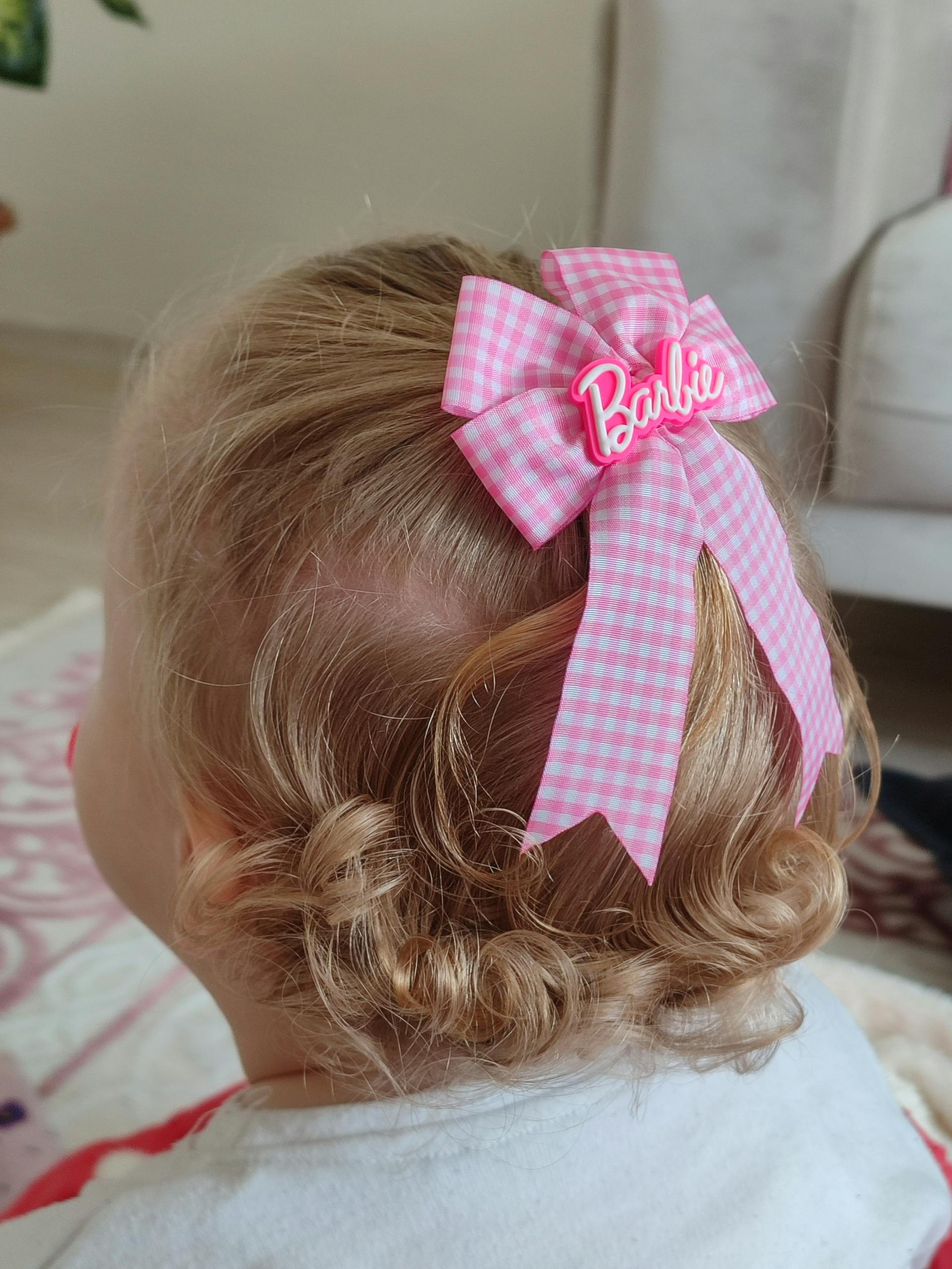 A close-up shot of a little girl with a pink bow in her hair | Source: Pexels