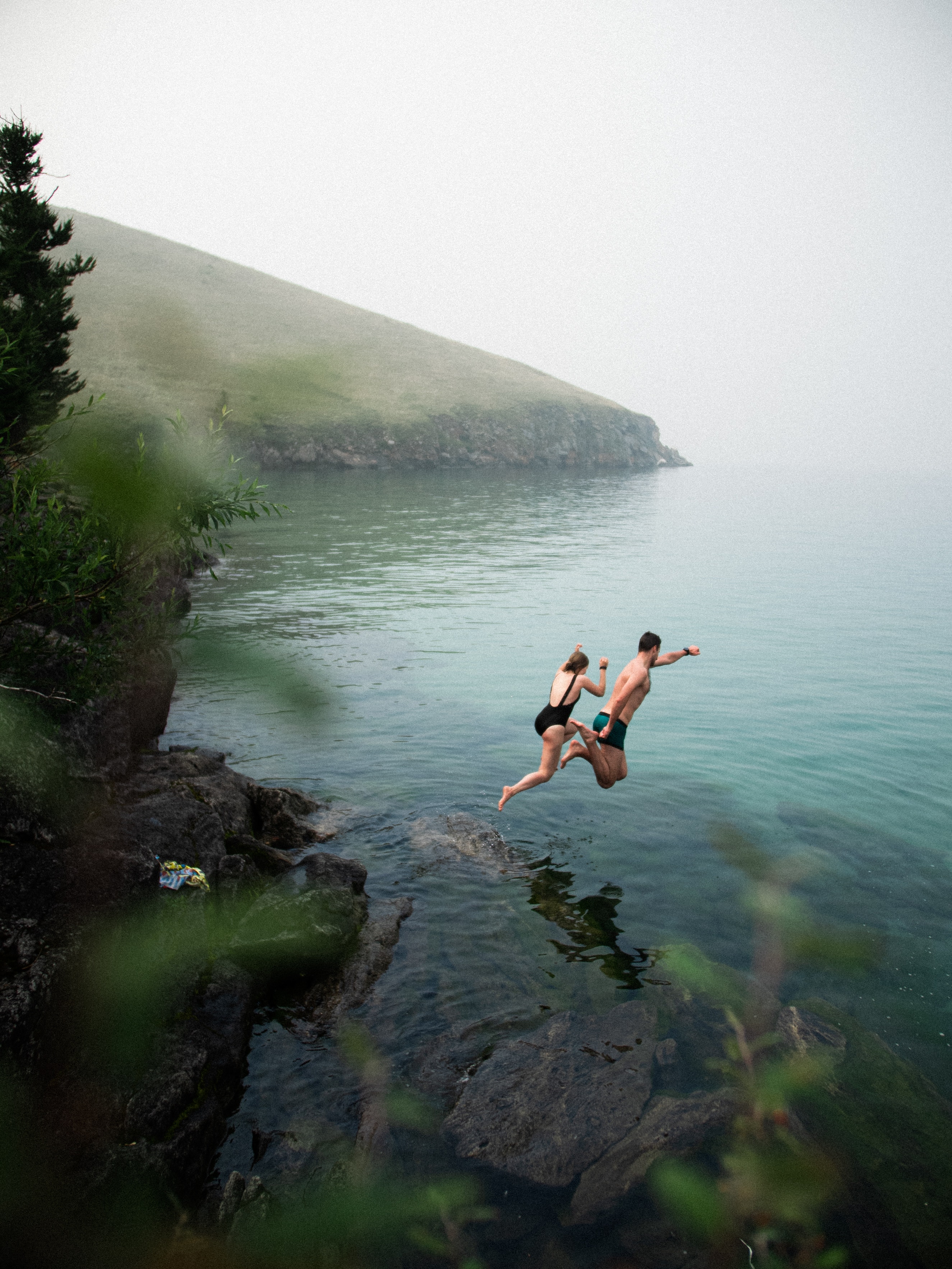 Two individuals jumping into water. | Source: Pexels