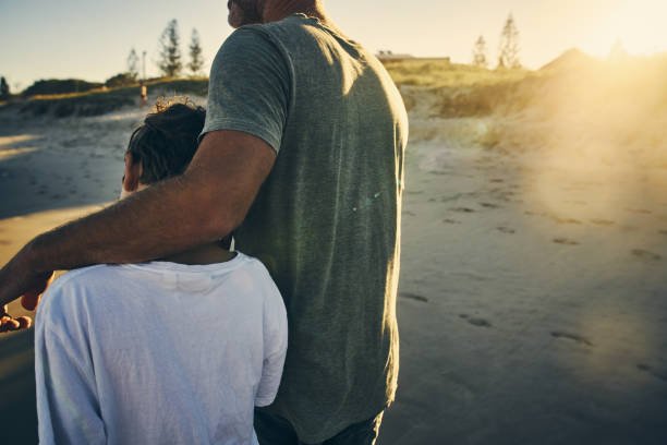 Un padre y su hijo caminando por la arena. | Foto: Pexels