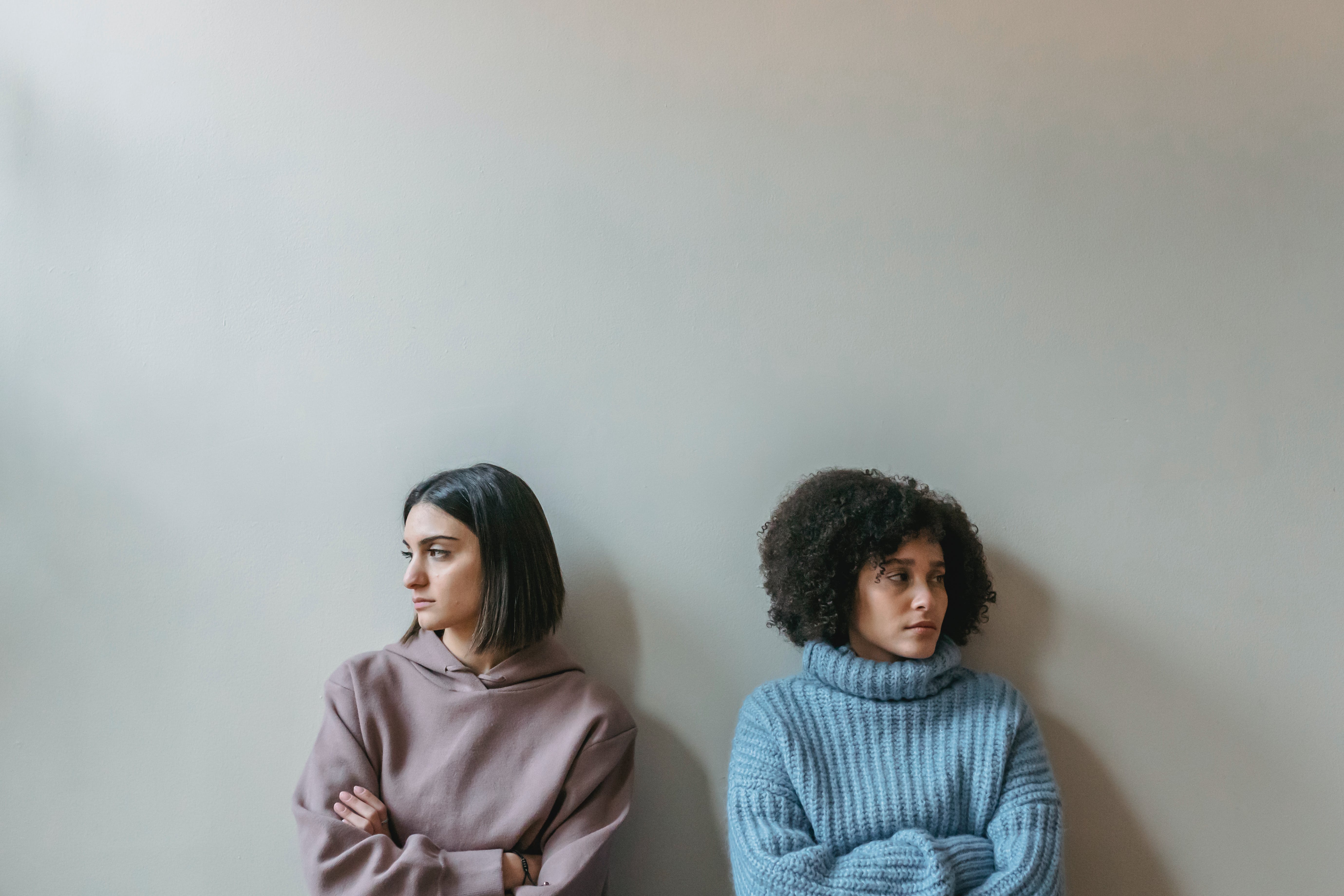 Two upset women looking away from each other with folded arms | Source: Pexels
