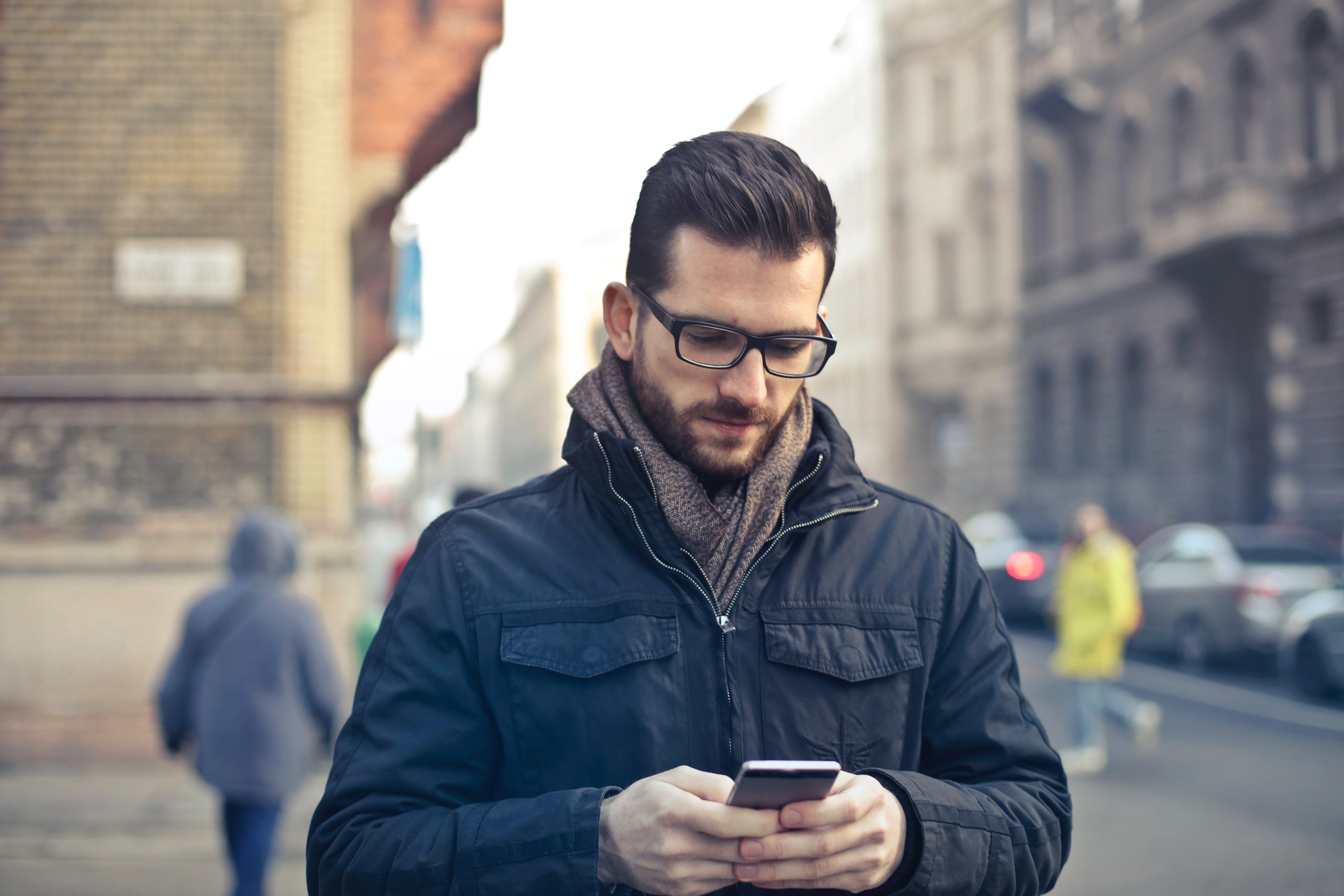 Man looking. Парень со смартфоном. Мужчина в очках на улице. Мужчина в очках осень. Человек смотрит в смартфон.