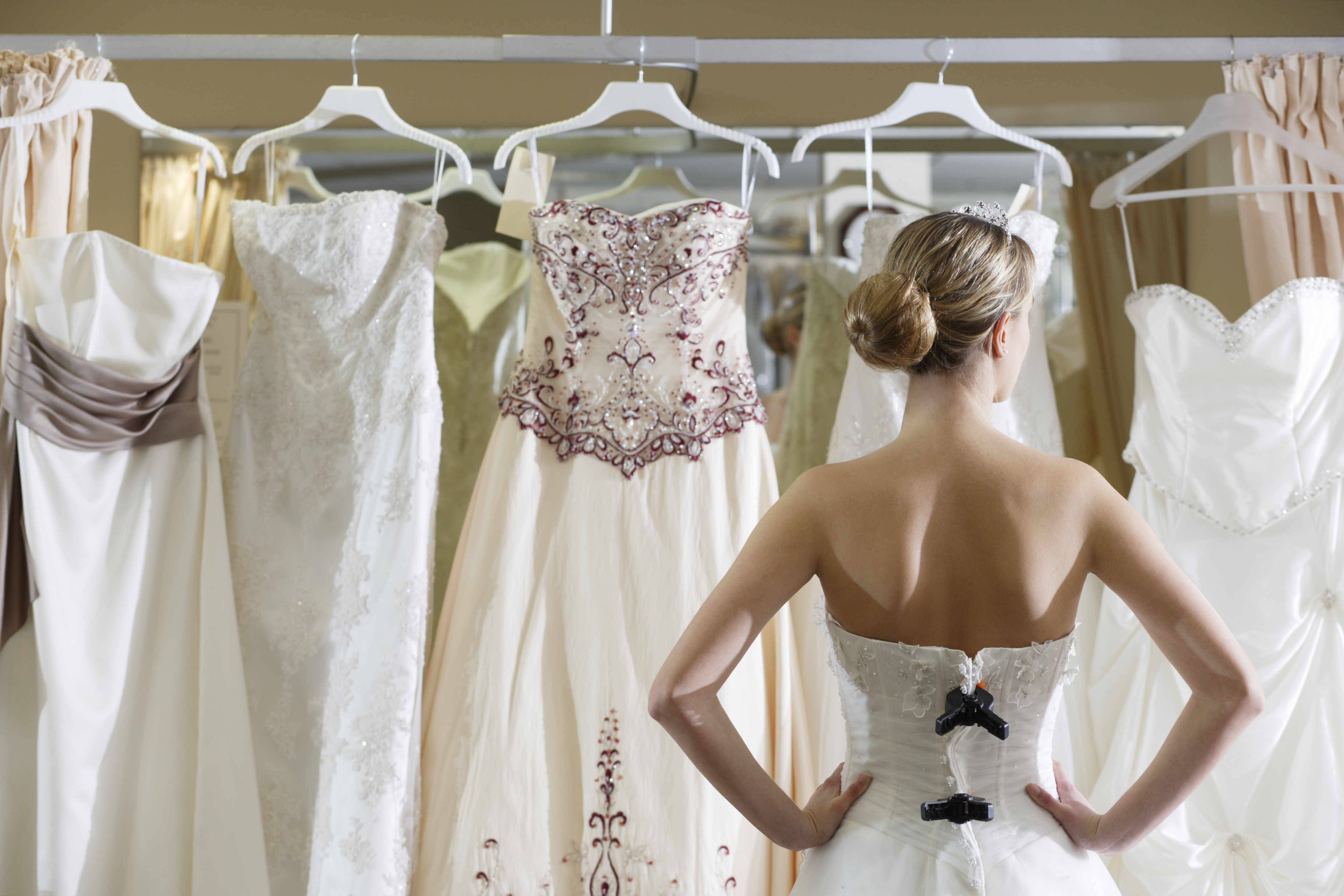 Bride looking at rack of dresses | Source: Getty Images