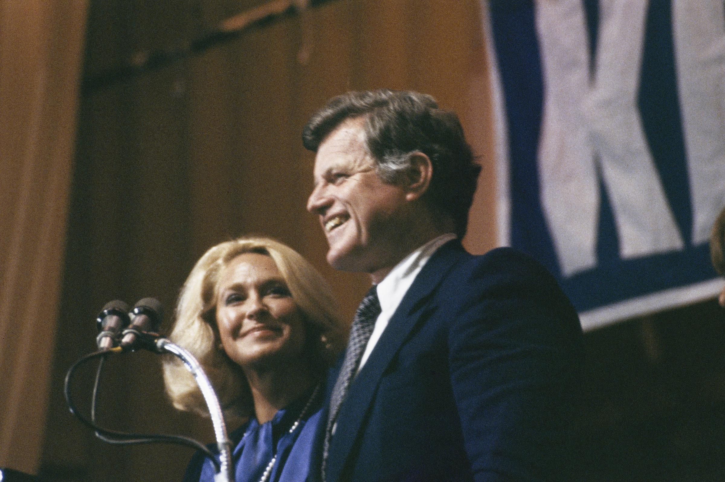Joan Kennedy smiles as her husband, Senator Ted Kennedy, addresses a crowd of supporters after narrowly winning the Pennsylvania presidential primary in Philadelphia on April 22, 1980. | Source: Getty Images