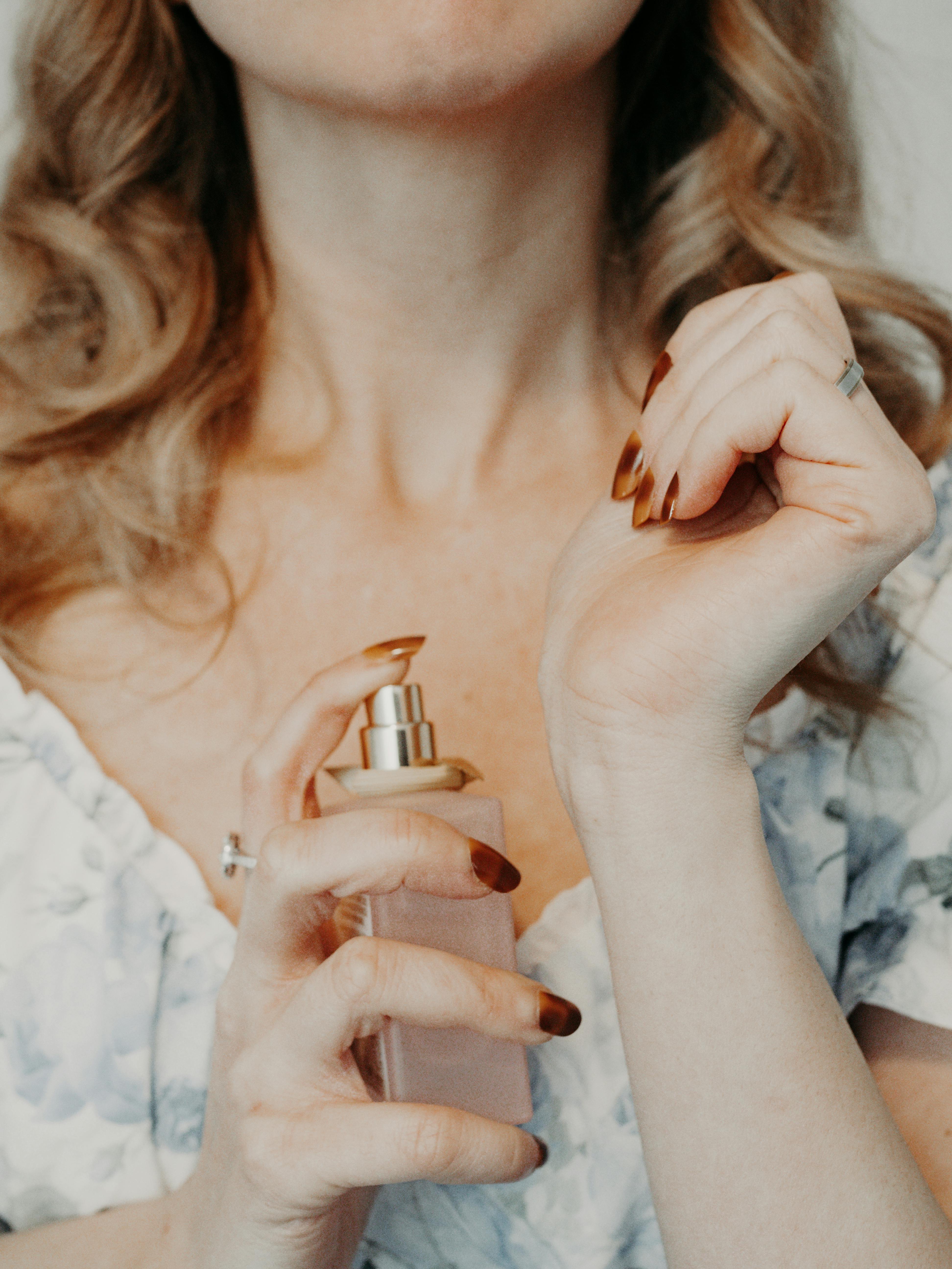 A woman spraying perfume on her wrist | Source: Pexels