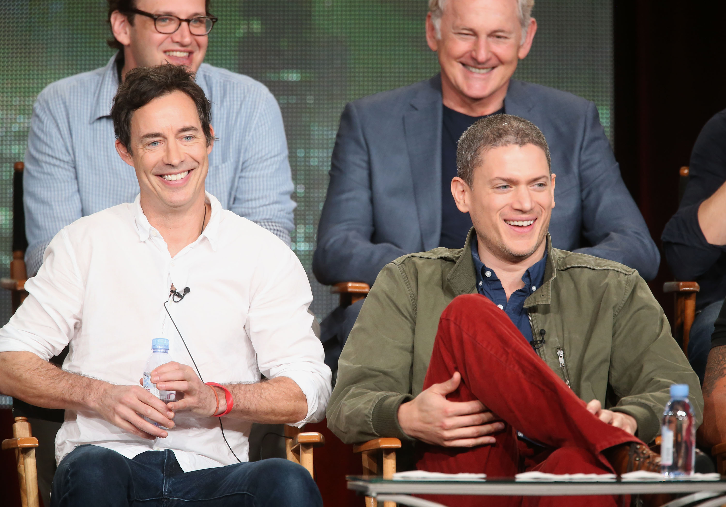 Tom Cavanagh (L) and Wentworth Miller laugh onstage during the "Arrow" and "The Flash" panel as part of The CW 2015 Winter Television Critics Association press tour on January 11, 2015, in Pasadena, California. | Source: Getty Images