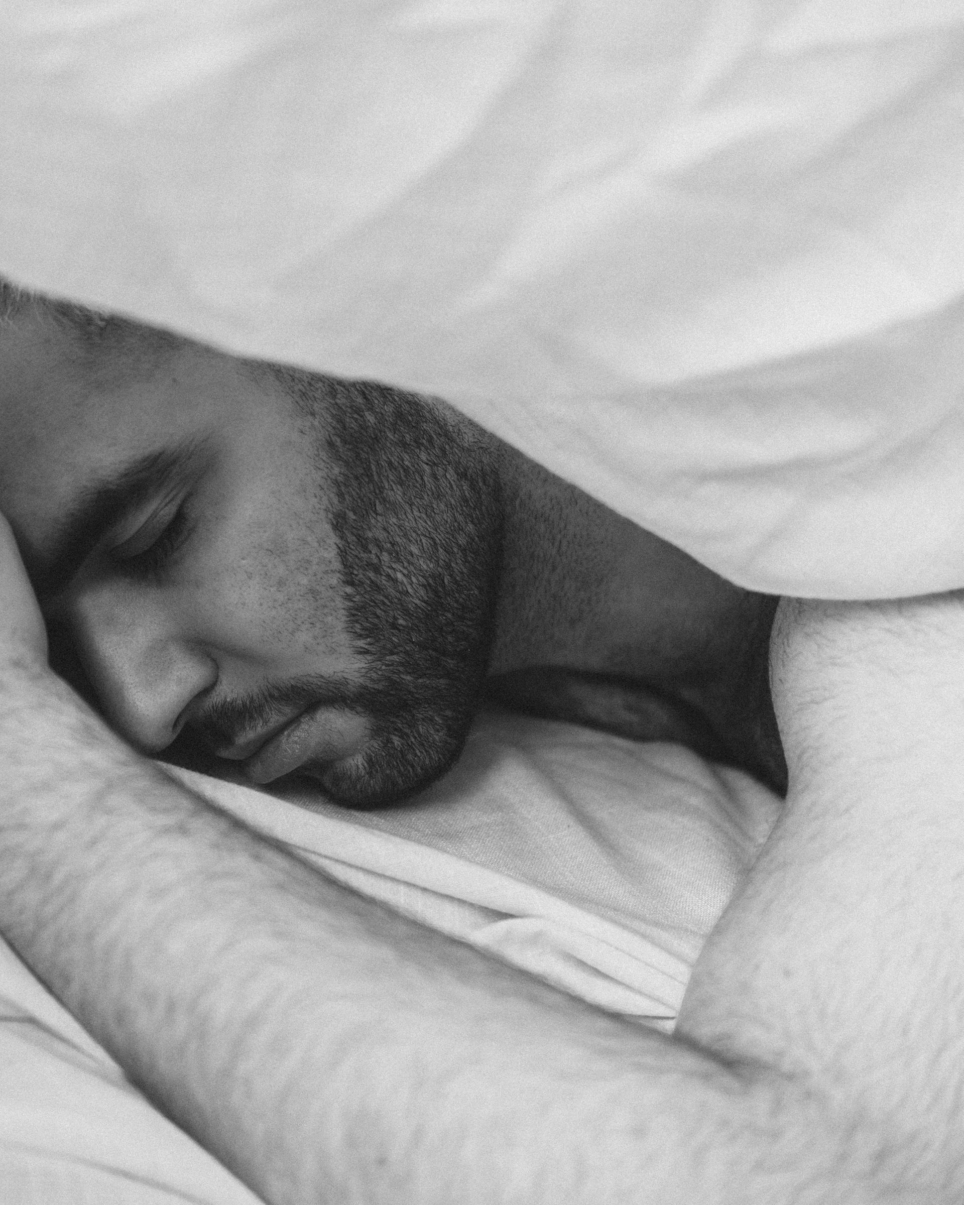 Grayscale shot of a man sleeping | Source: Pexels