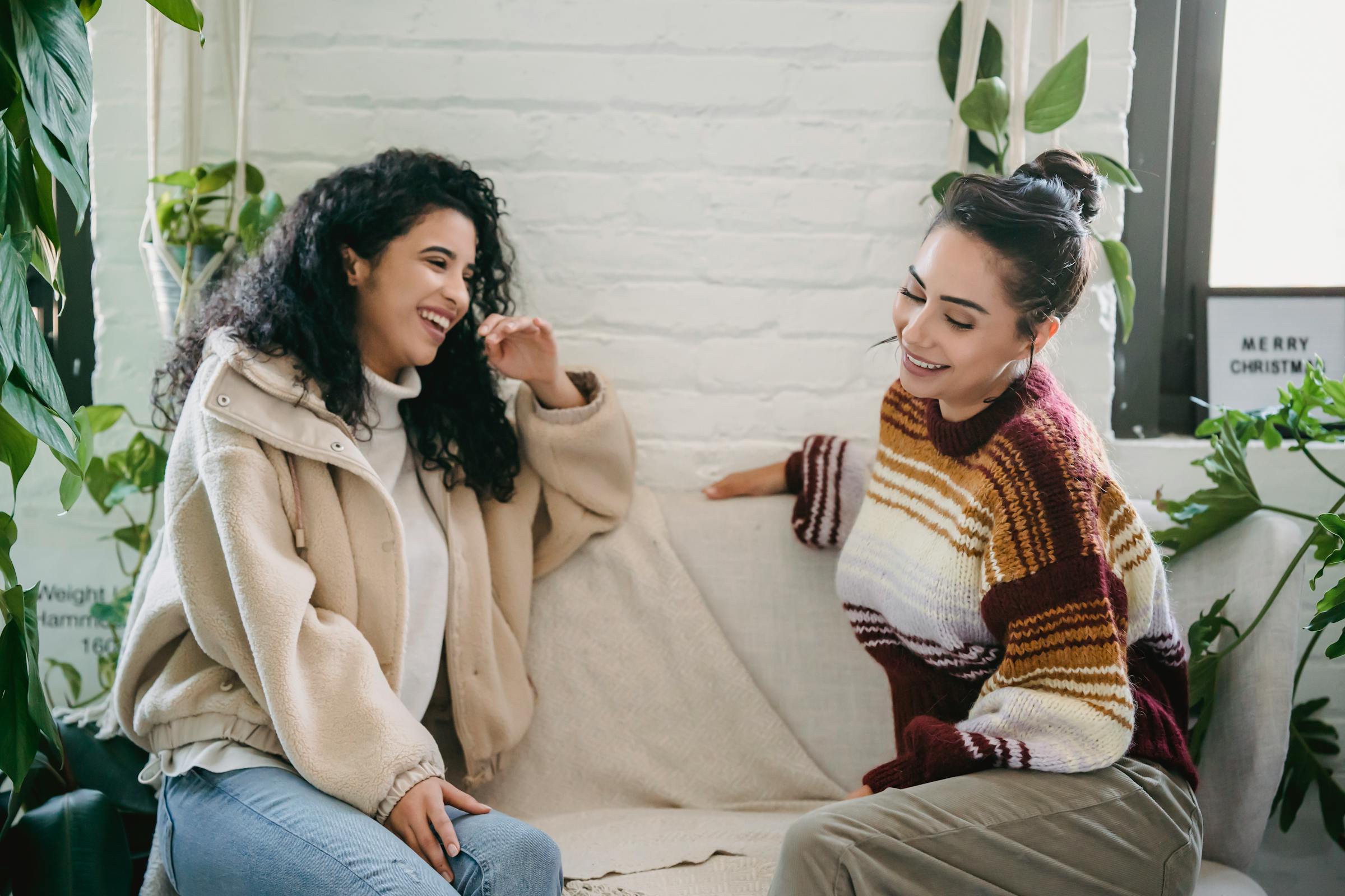 Two women laughing on a couch | Source: Pexels