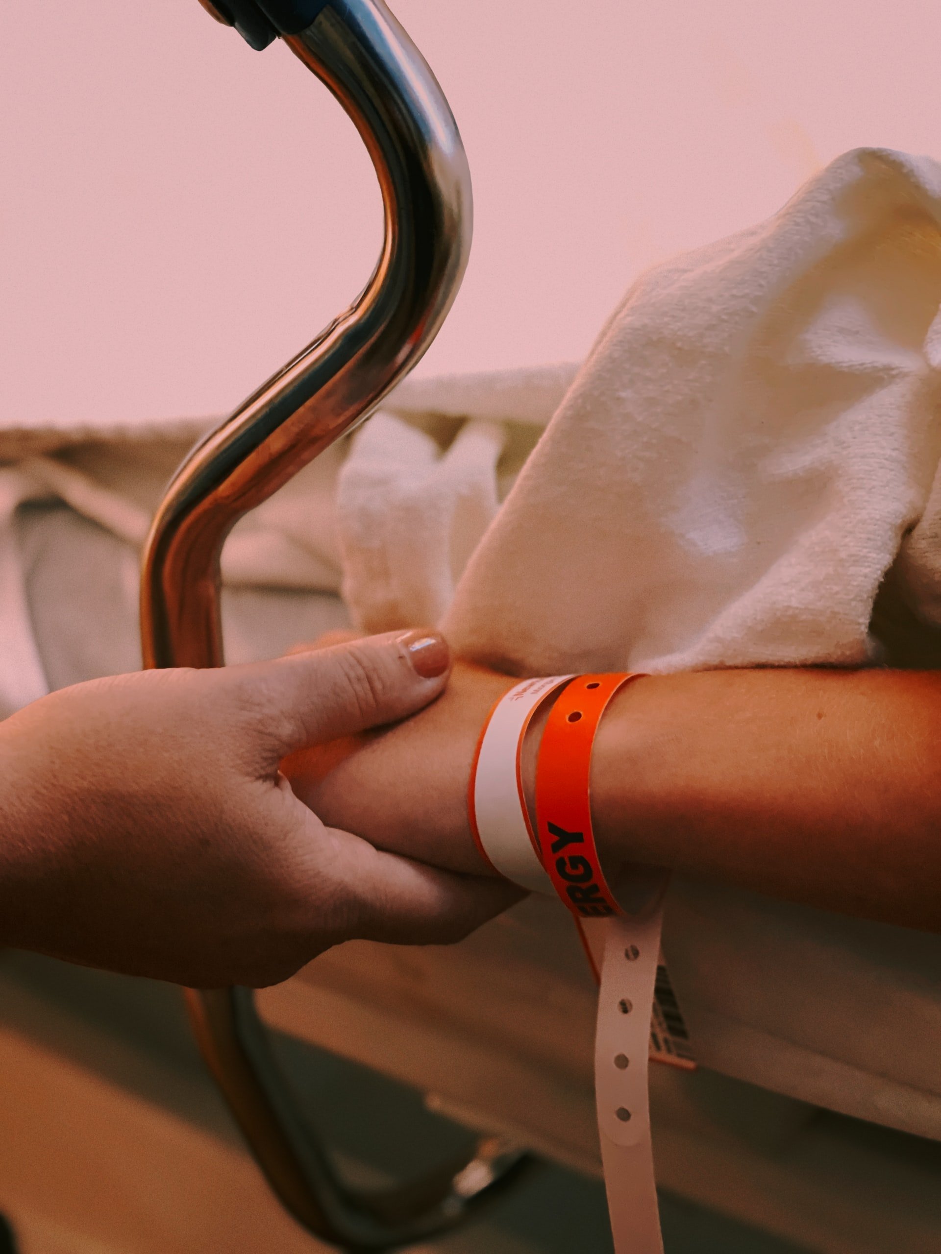 Un hombre tomando la mano de una persona recostada en la cama de un hospital. | Foto: Unsplash