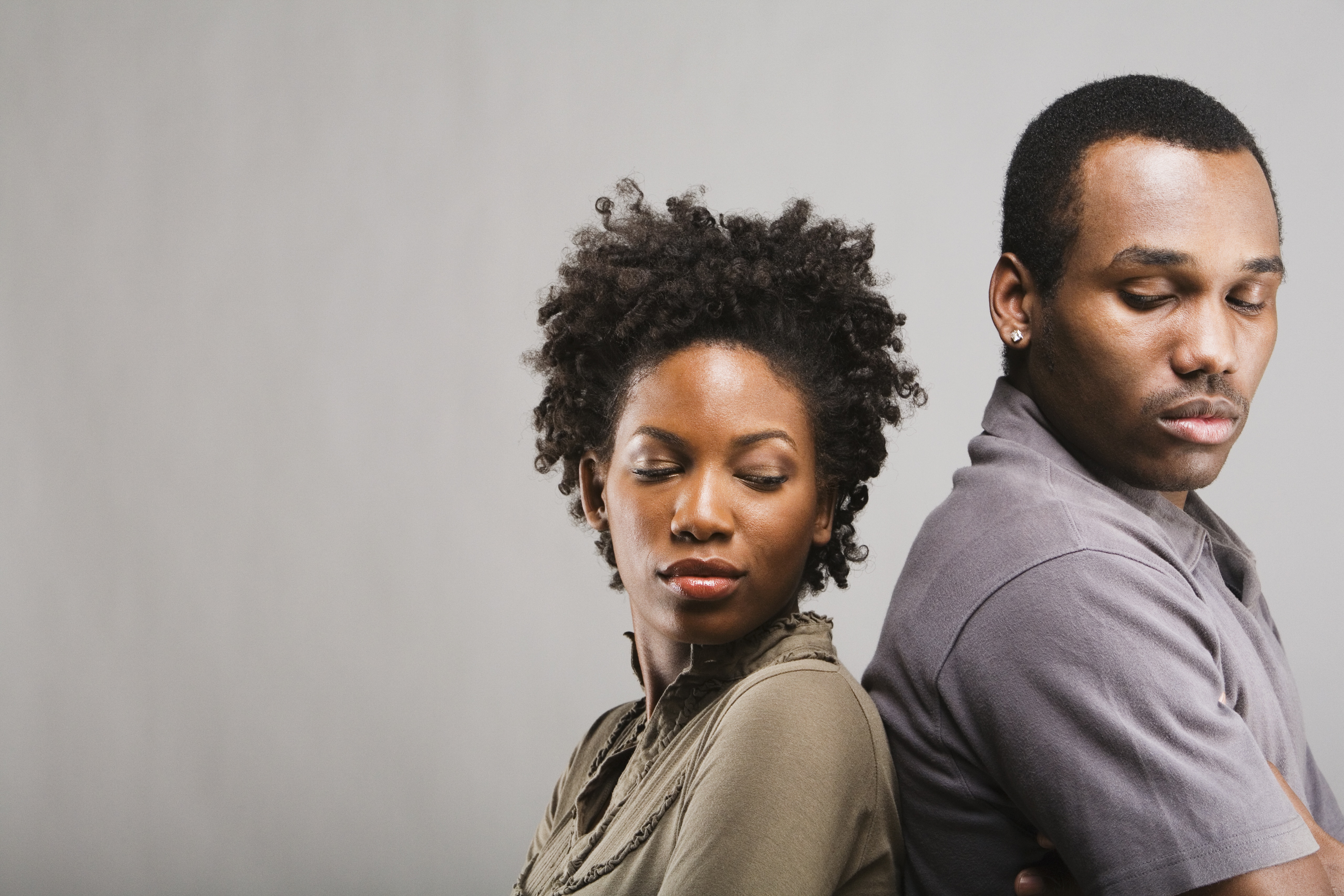 Angry African American couple standing back to back | Source: Getty Images
