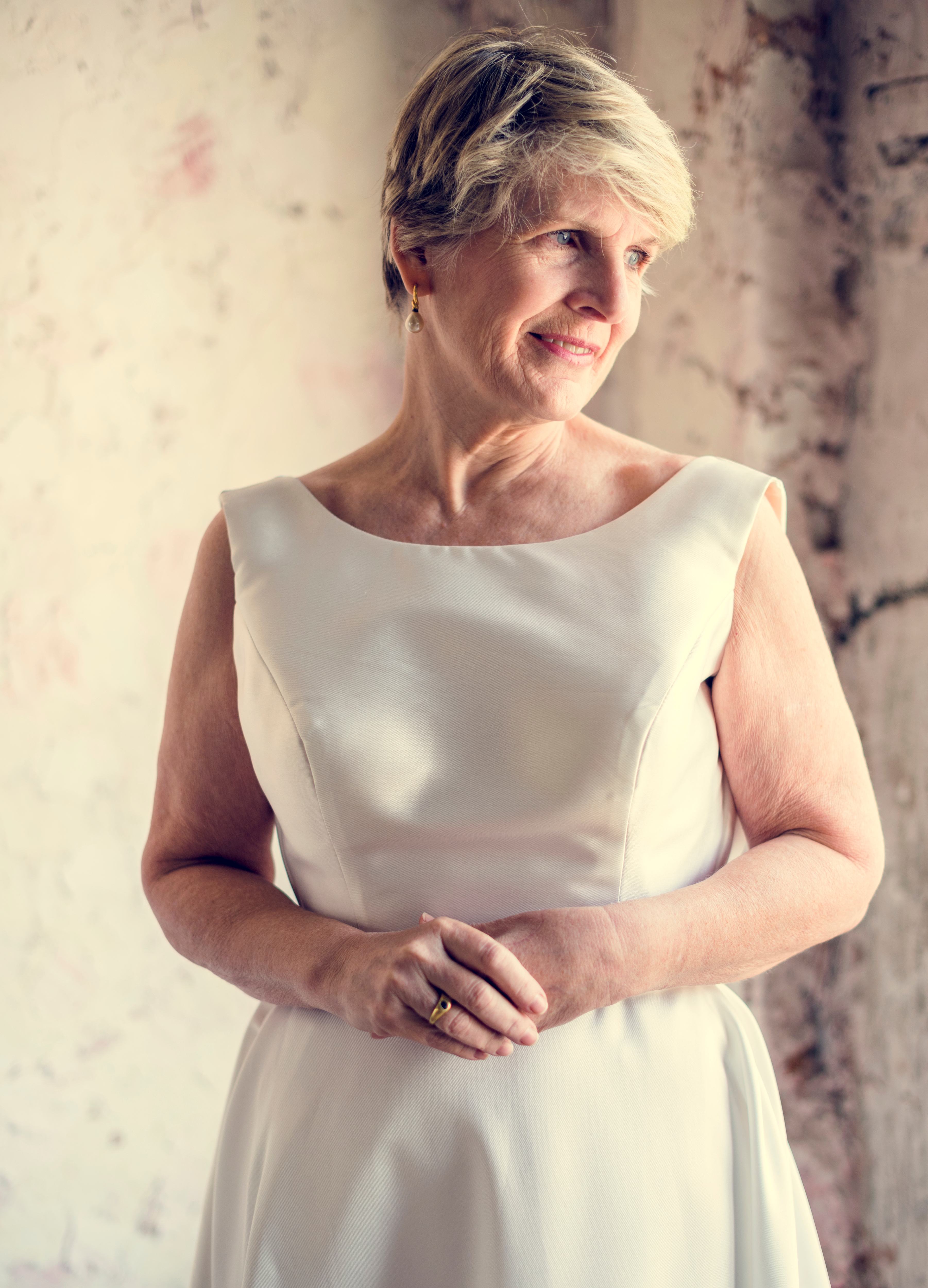 A senior woman in a white dress | Source: Shutterstock