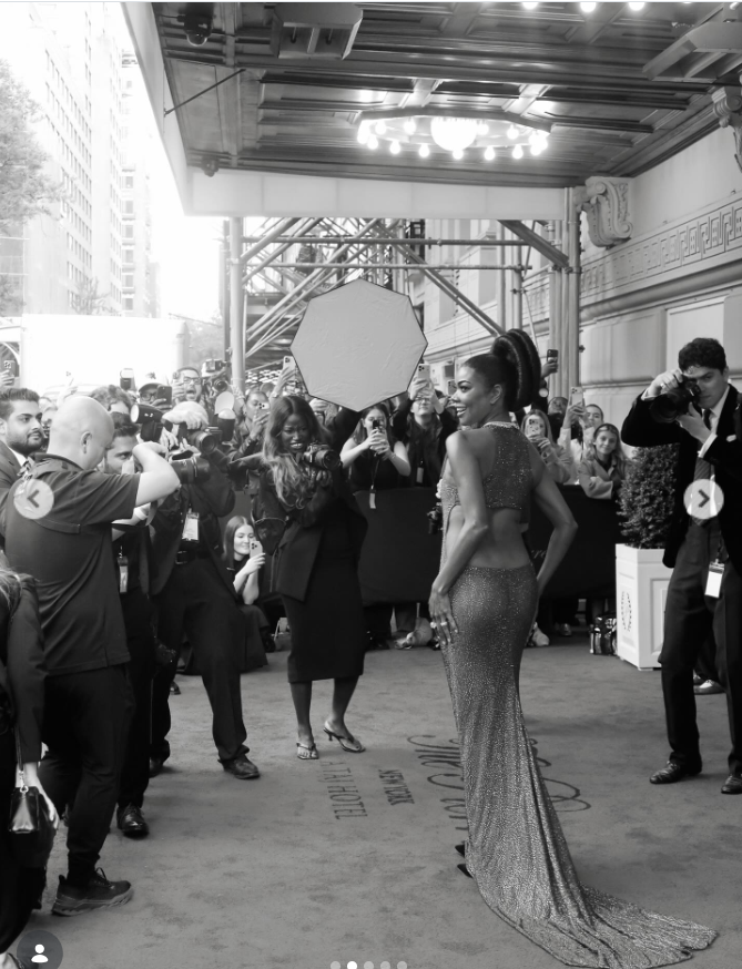 Gabrielle Union turns slightly as photographers capture her shimmering bronze gown from behind. The dramatic train trails along the carpet, adding movement and elegance to the moment. | Source: Instagram/gabunion