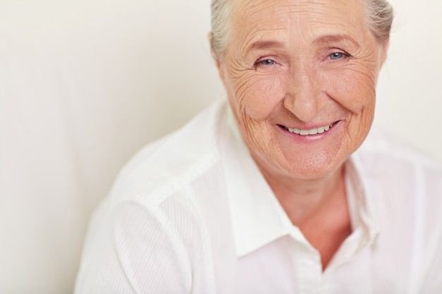 Femme âgée avec une chemise blanche. l Source : Shutterstock