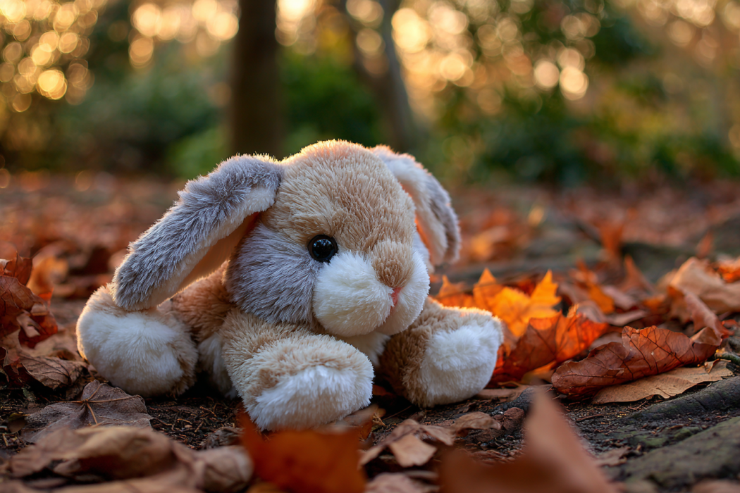 A stuffed rabbit lying on the ground in a park | Source: Midjourney