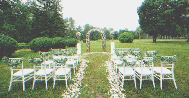 Sillas decoradas con flores y un arco decorado para una boda en un jardín. | Foto: Shutterstock