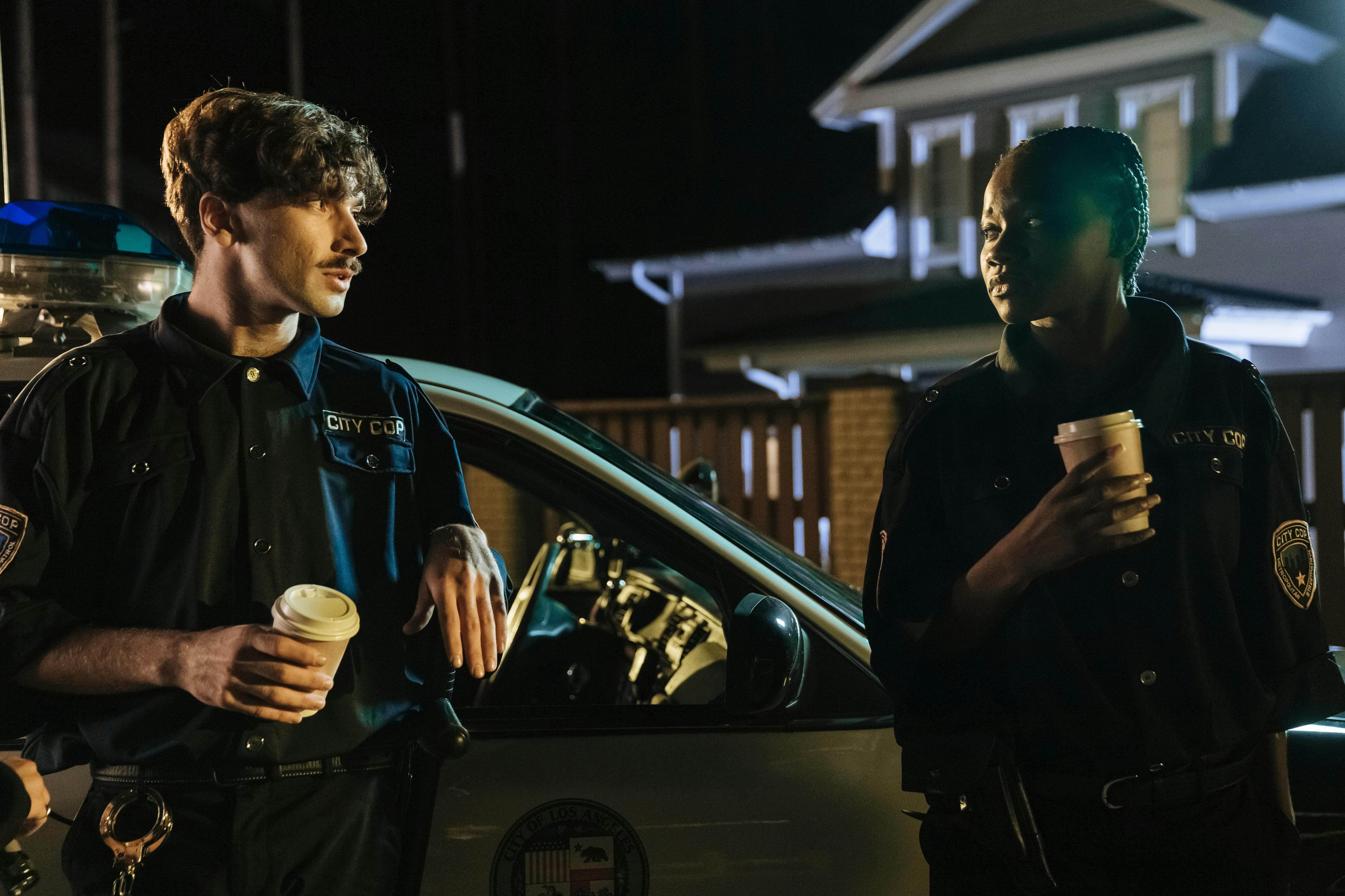 Police officers standing next to a patrol car | Source: Pexels
