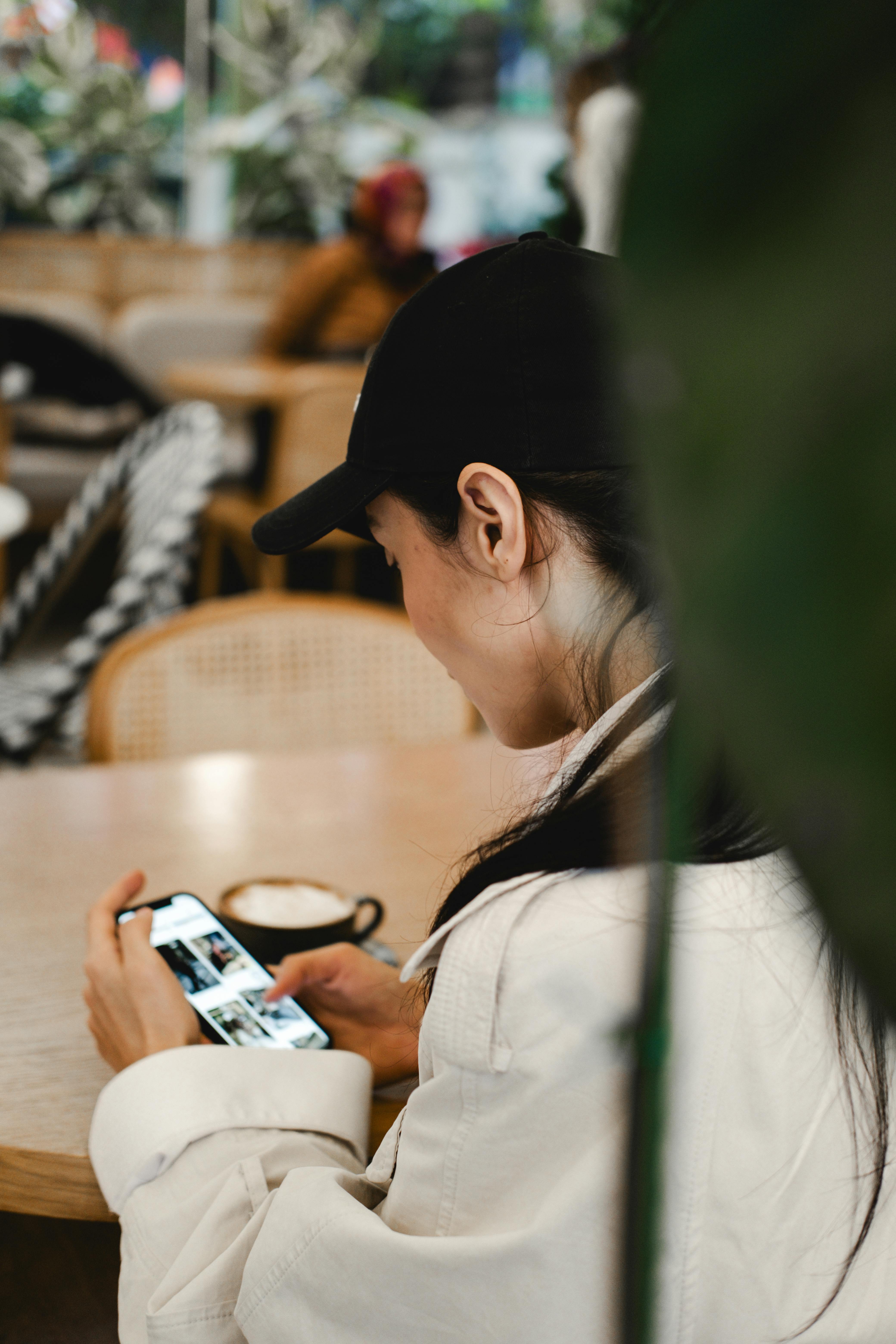 A woman checking her phone in a restaurant | Source: Pexels