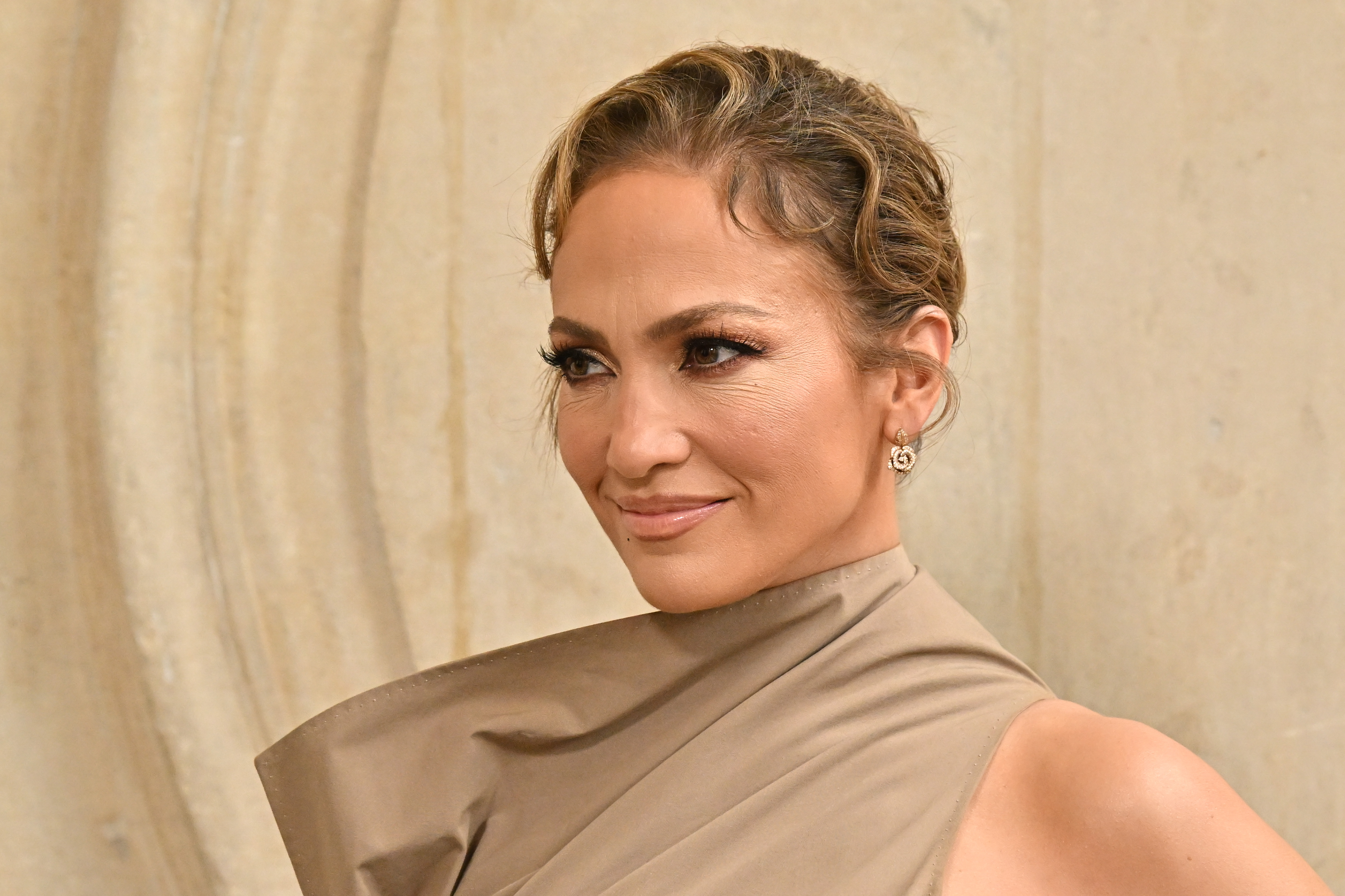 Jennifer Lopez shows a slight, yet serious smile at Christian Dior's Fall/Winter 2024 Haute Couture show during Paris Fashion Week on June 24, 2024 | Source: Getty Images